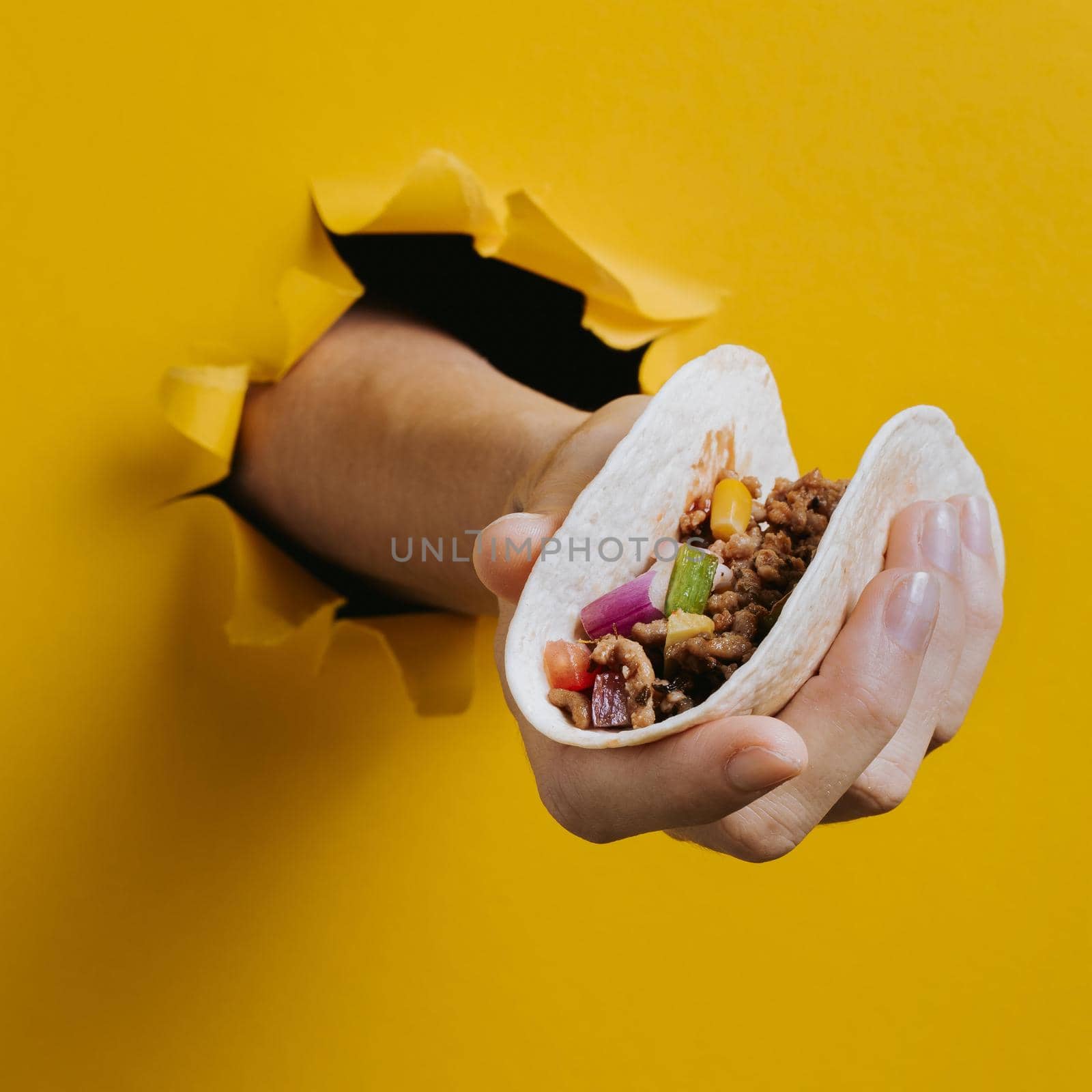 close up hand holding taco