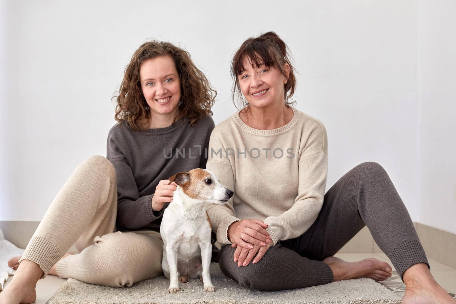 Smiling mother and daughter with dog at home by Demkat