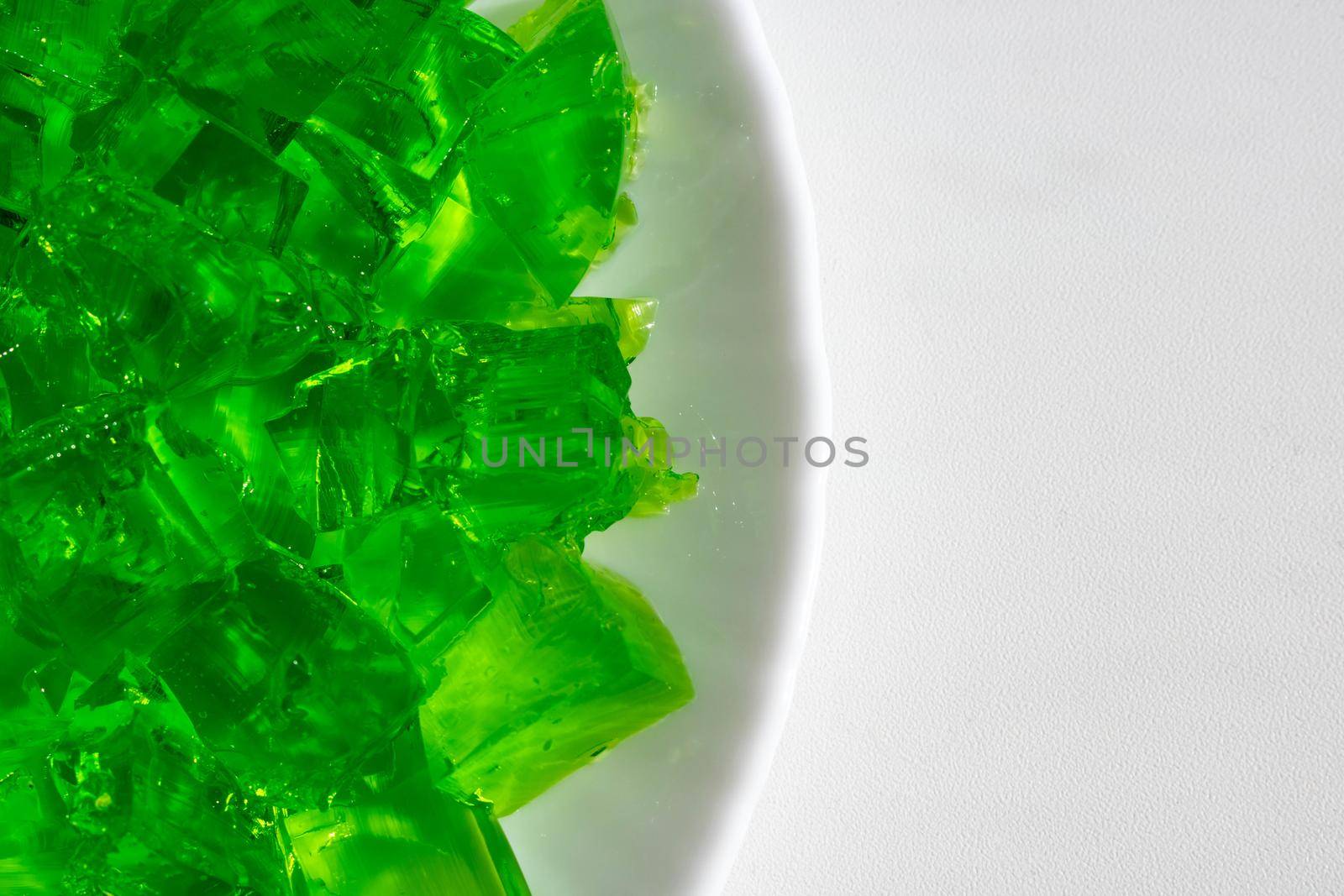 Delicious green jelly cube on white background.