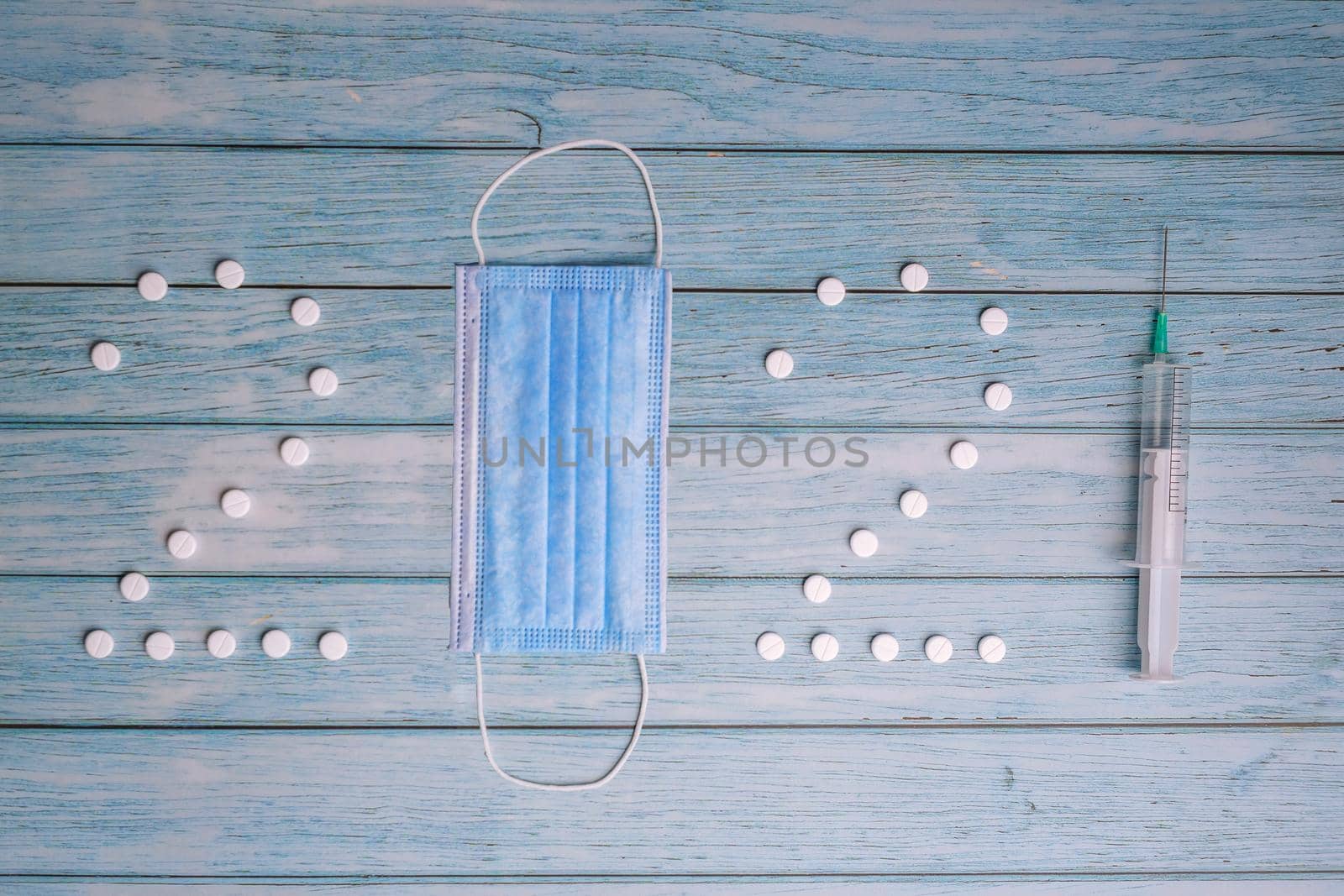 2021 written by pills, medical mask and syringe on blue wooden background. Christmas 2021 New Year. Mask, pills, and syringe. Healthlife concept.
