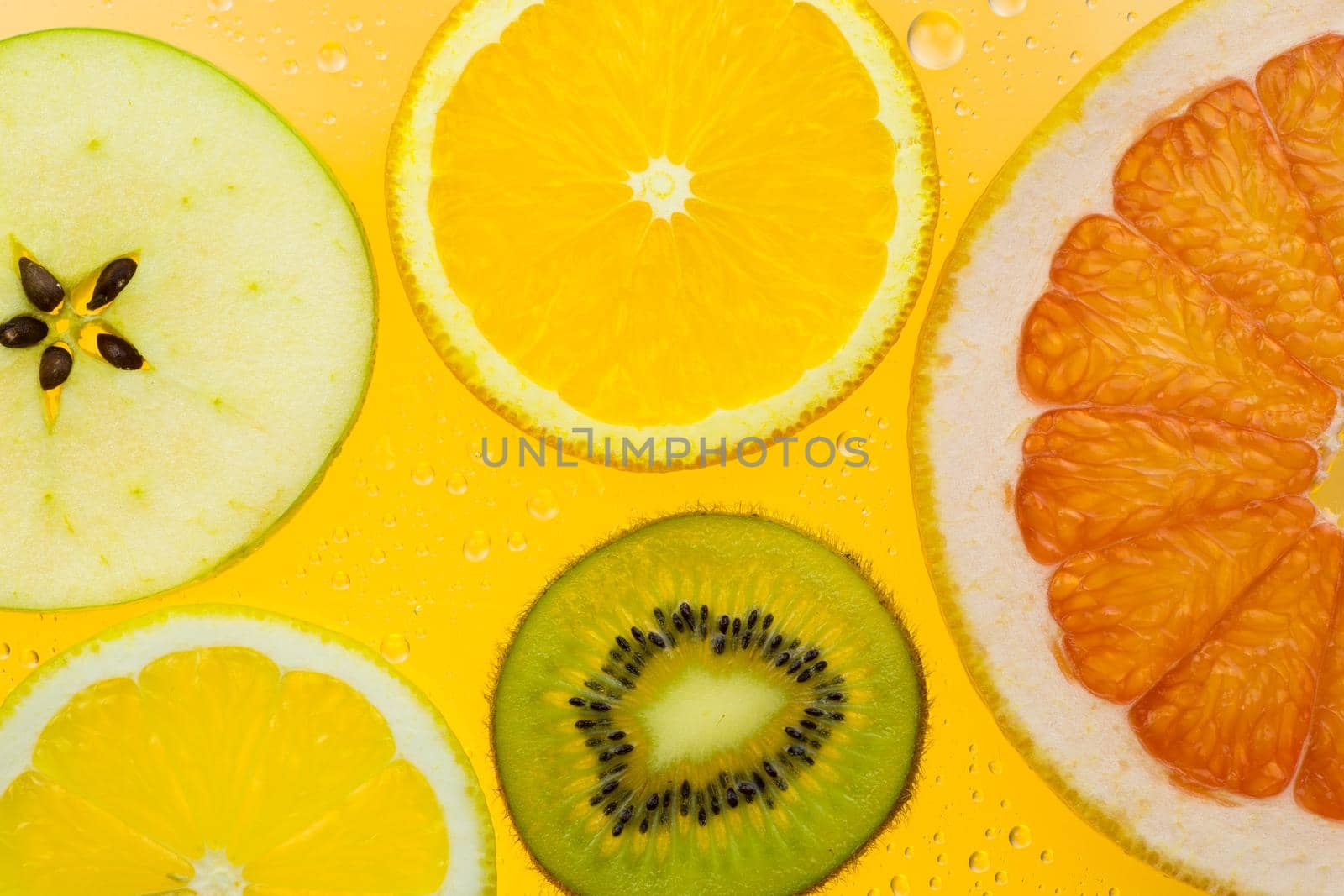 orange grapefruit and kiwi slices on yellow background