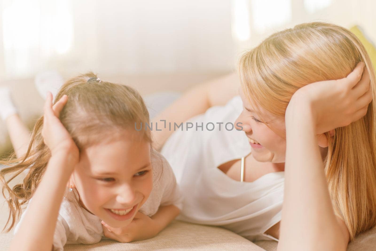 Mum and her cute daughter child girl are playing, smiling and hugging. Happy mother's day. Family holiday and togetherness.
