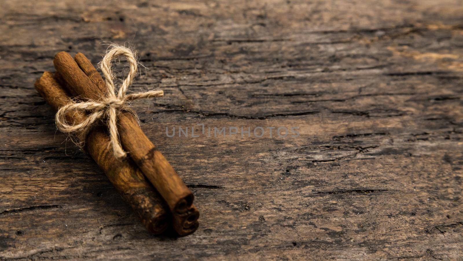 A pile of cinnamon sticks on old wooden table with copy space. Christmas decoration. Christmas card by lunarts