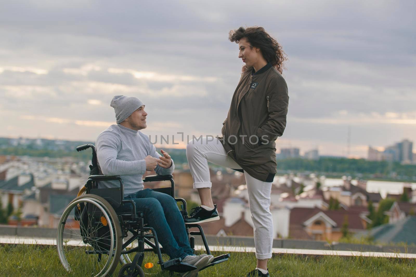 Beautiful woman with young disabled man on the hill overlooking the city, close up