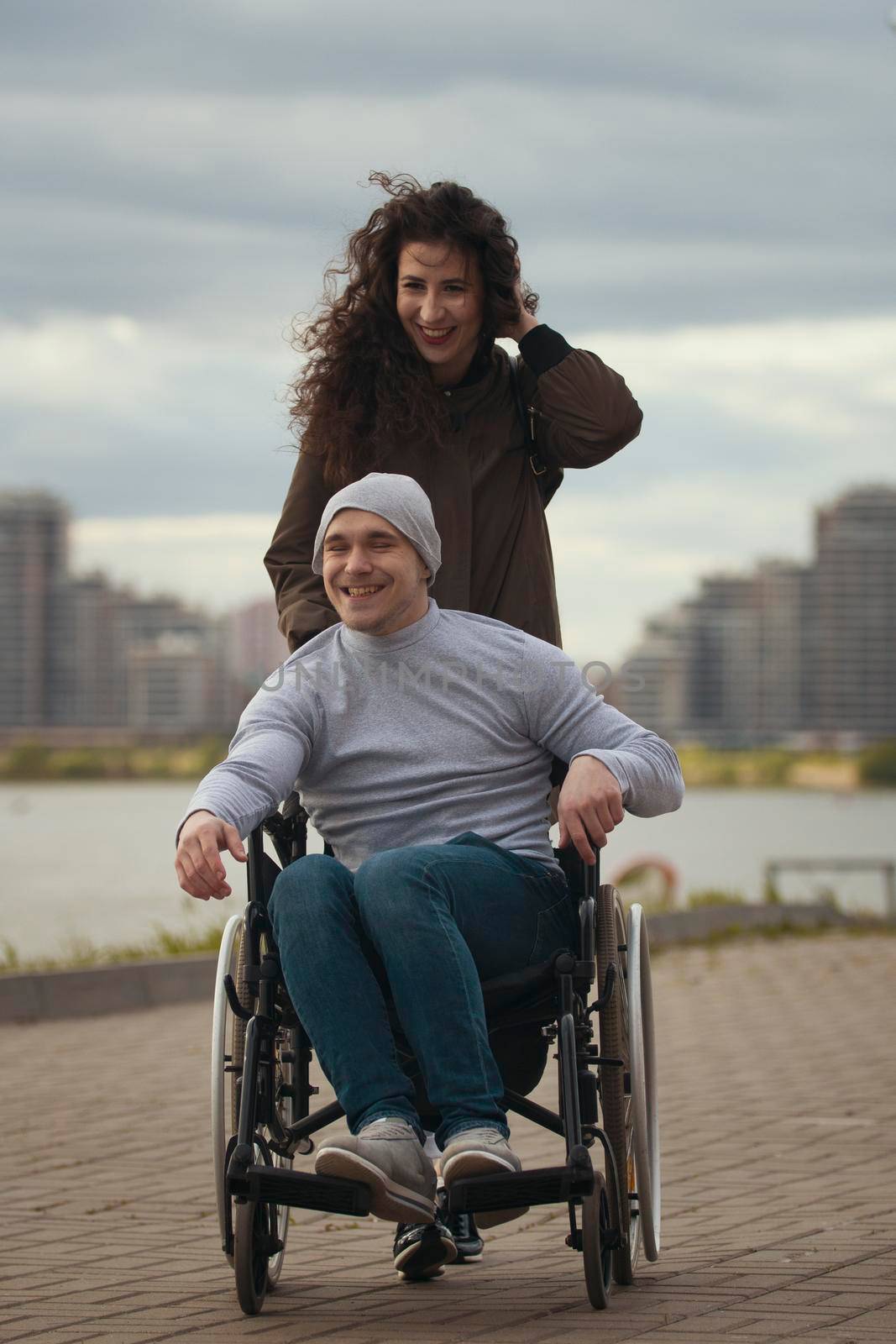 Portrait of happy couple - caring woman with disabled man in wheelchair by Studia72