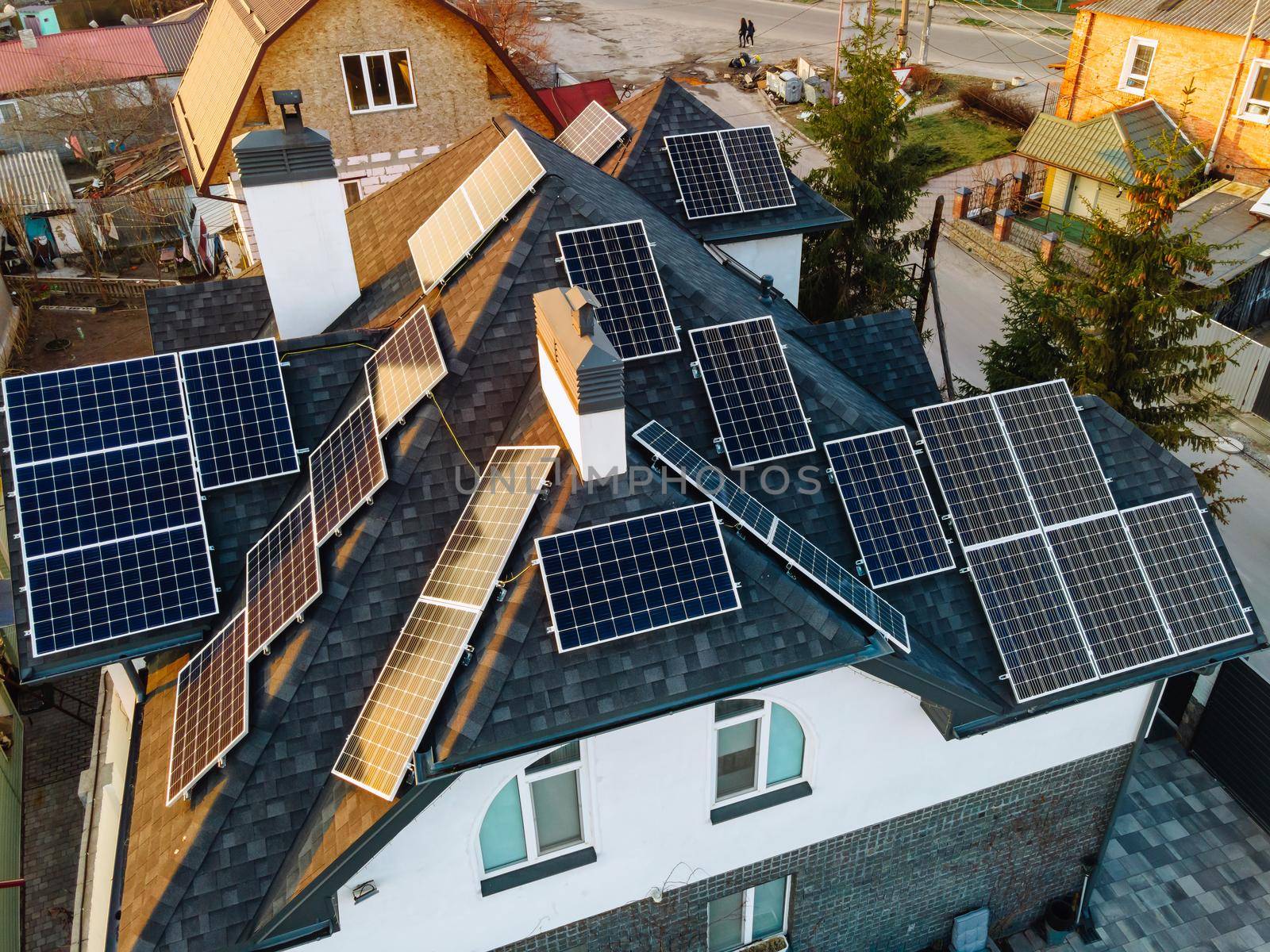 Aerial view of solar photovoltaic panels on a own house roof in small european city. Renewable green power concept