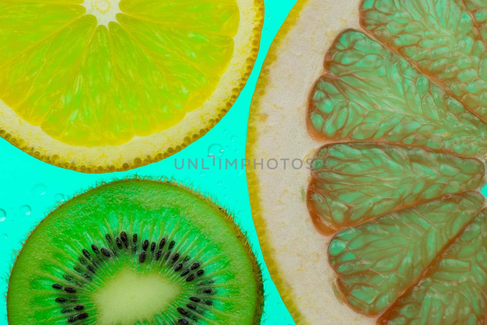 orange grapefruit and kiwi slices on green background