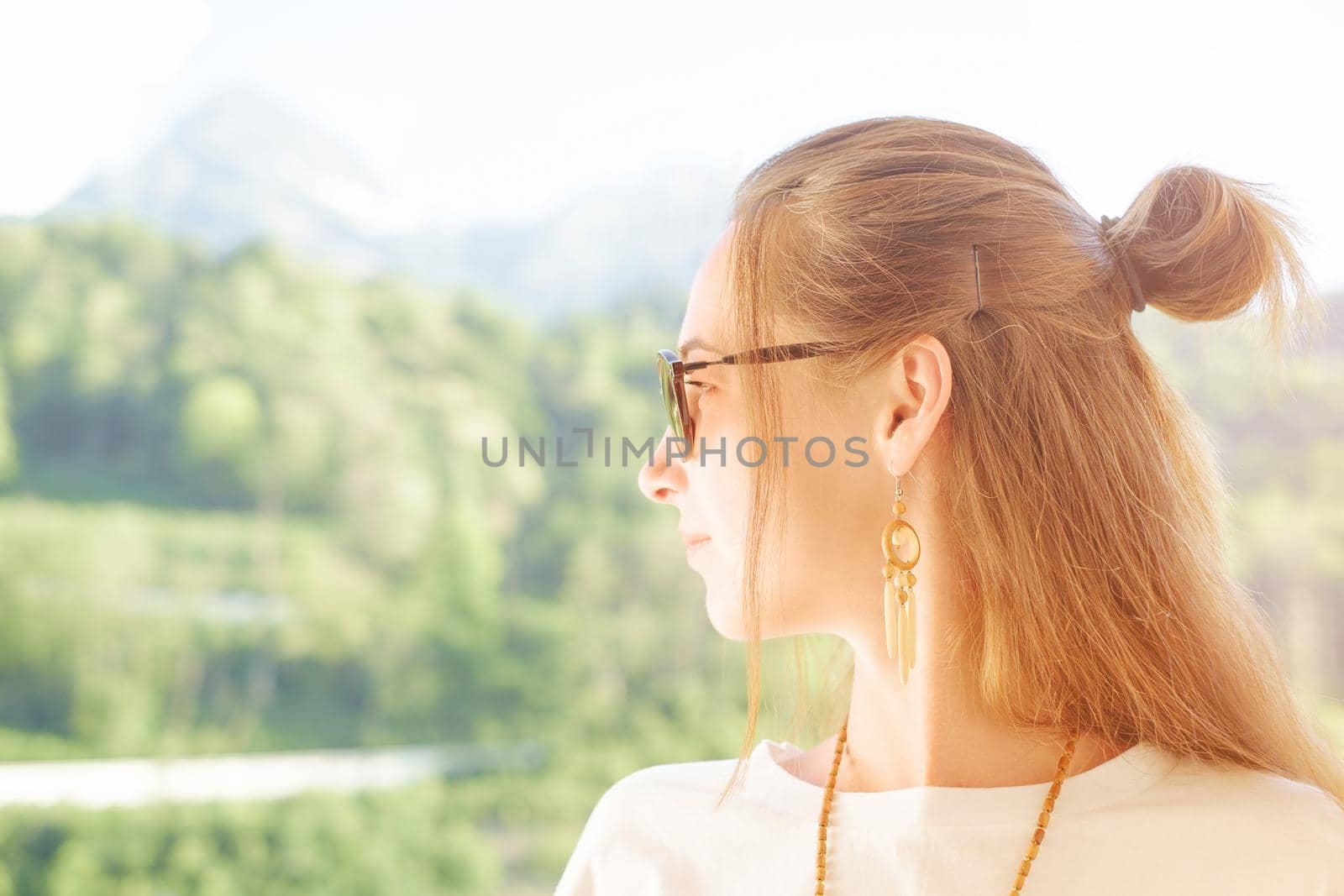 Portrait of beautiful young woman enjoying view of summer nature outdoor.