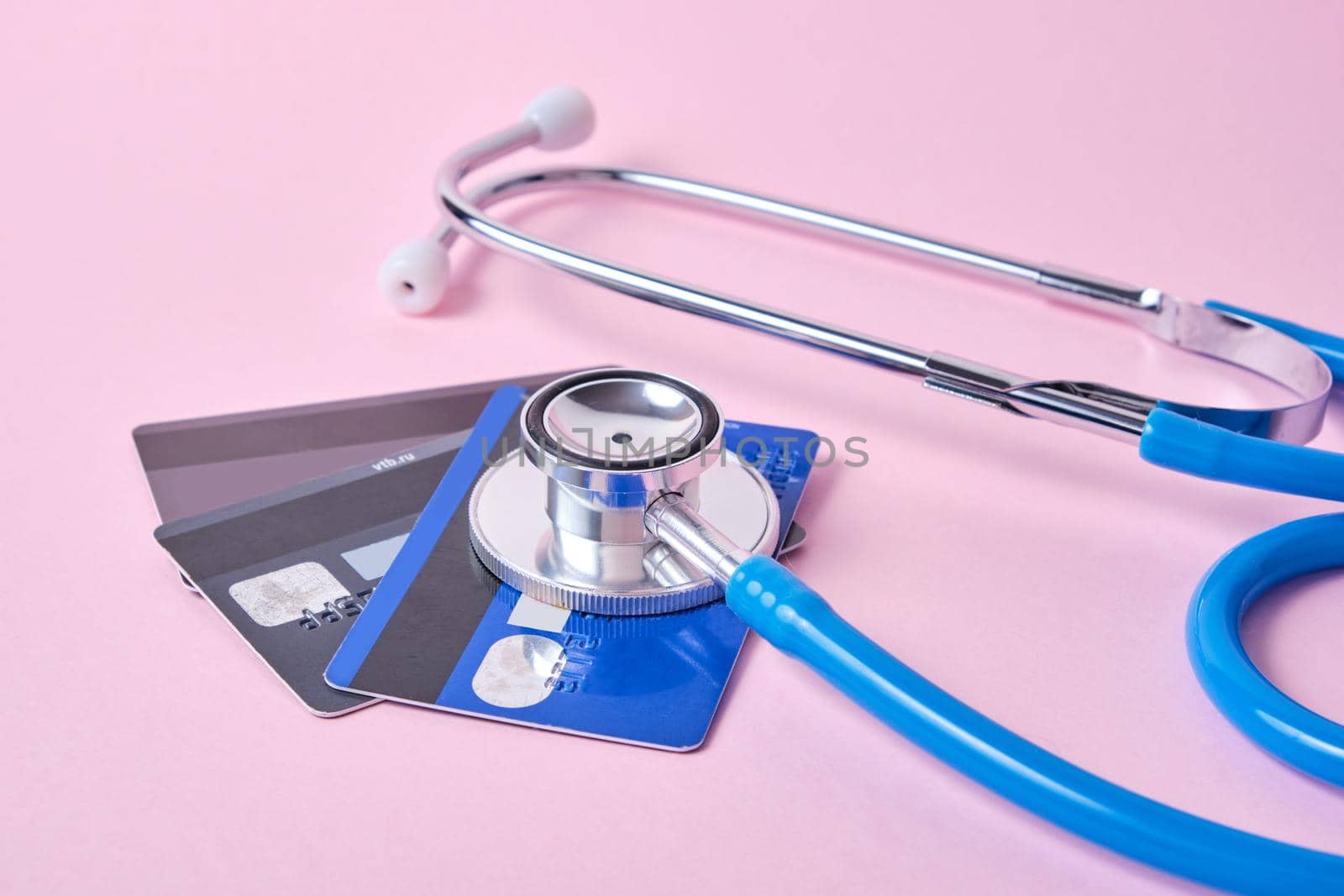 stethoscope and credit cards on a pink background, the concept of the impact of the crisis on the exchange rate and income of the population, the crisis due to coronavirus