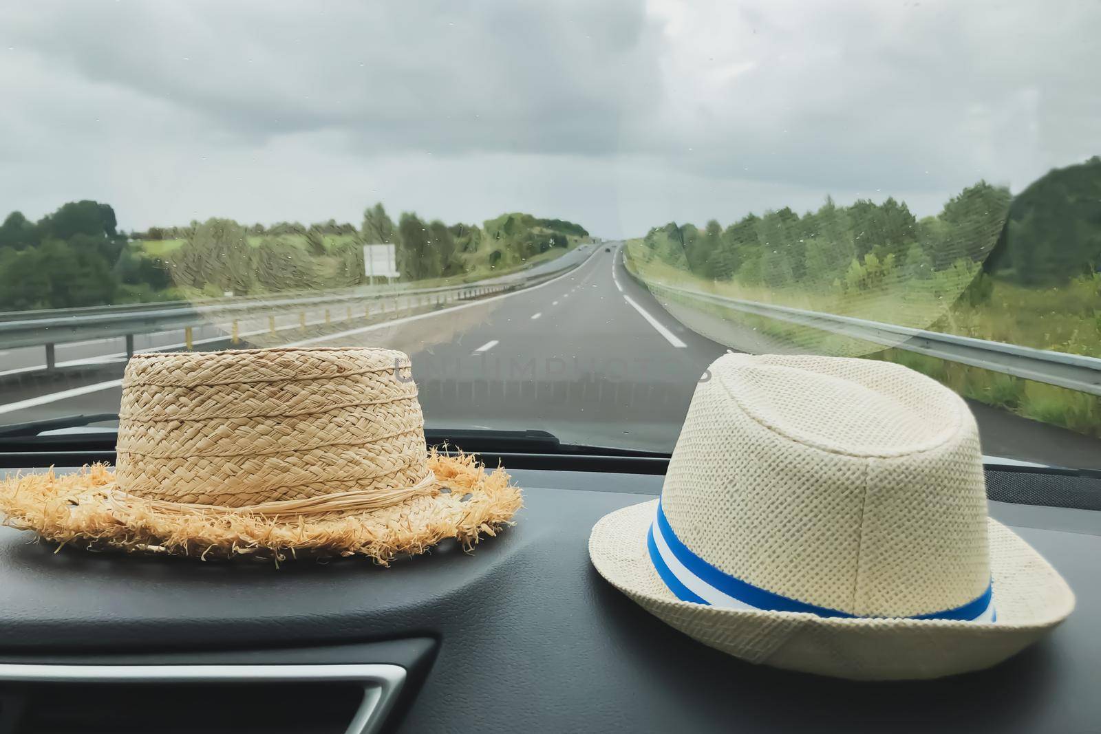 Two straw hats in the car Rural landscape outside the window