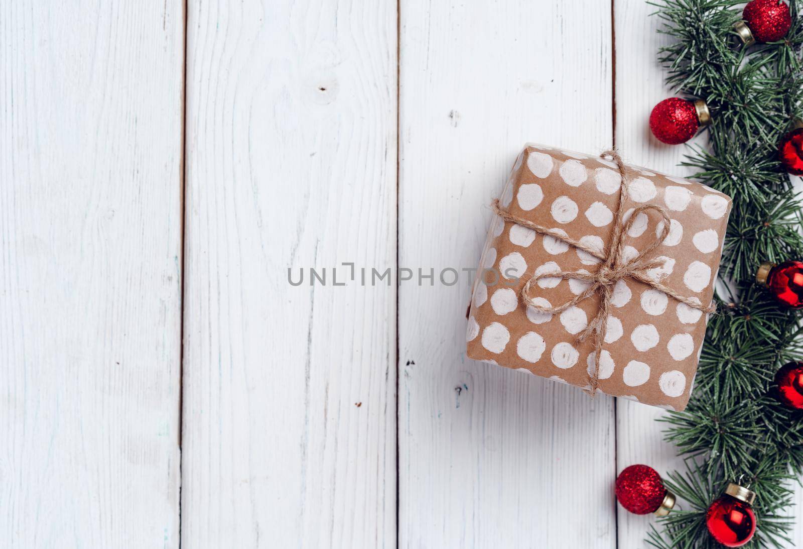 White wooden background with coniferous branches and Christmas decorations, top view