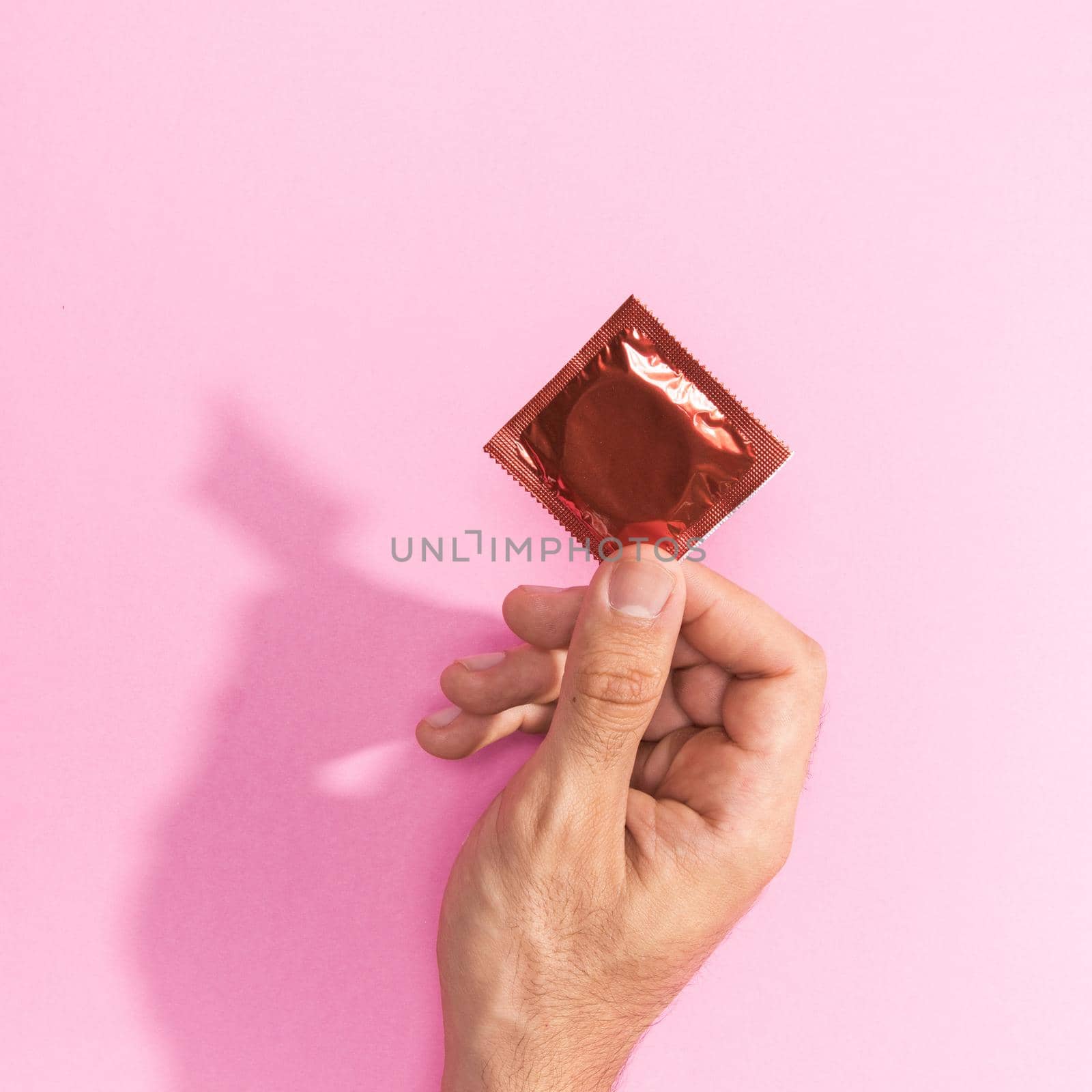 close up man holding up red condom by Zahard