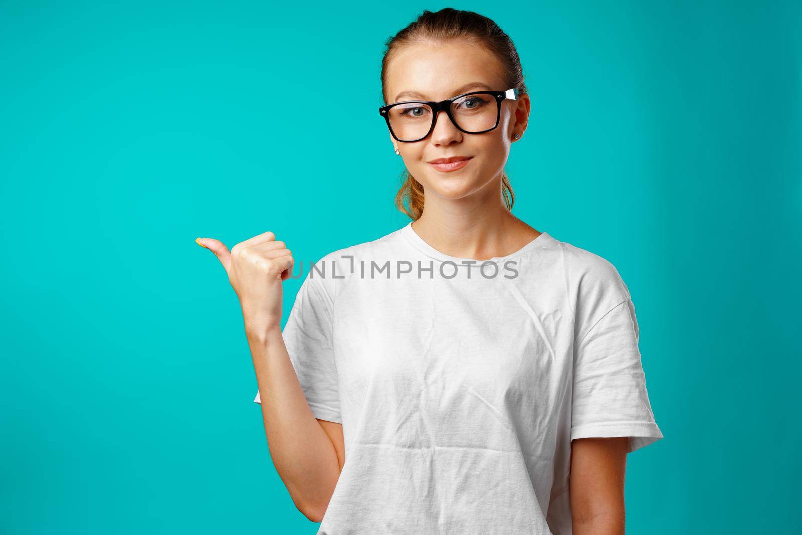 Portrait charming pretty cheerful girl showing copy space with her finger