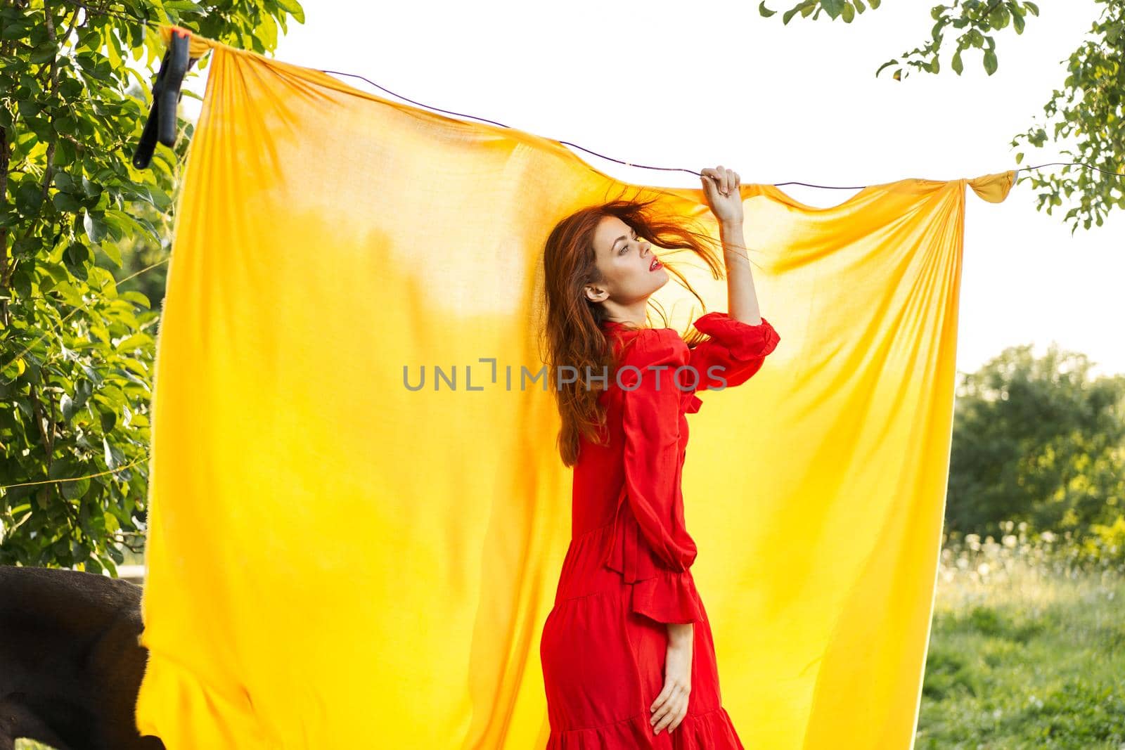 pretty woman in red dress gesturing with her hands nature yellow background. High quality photo