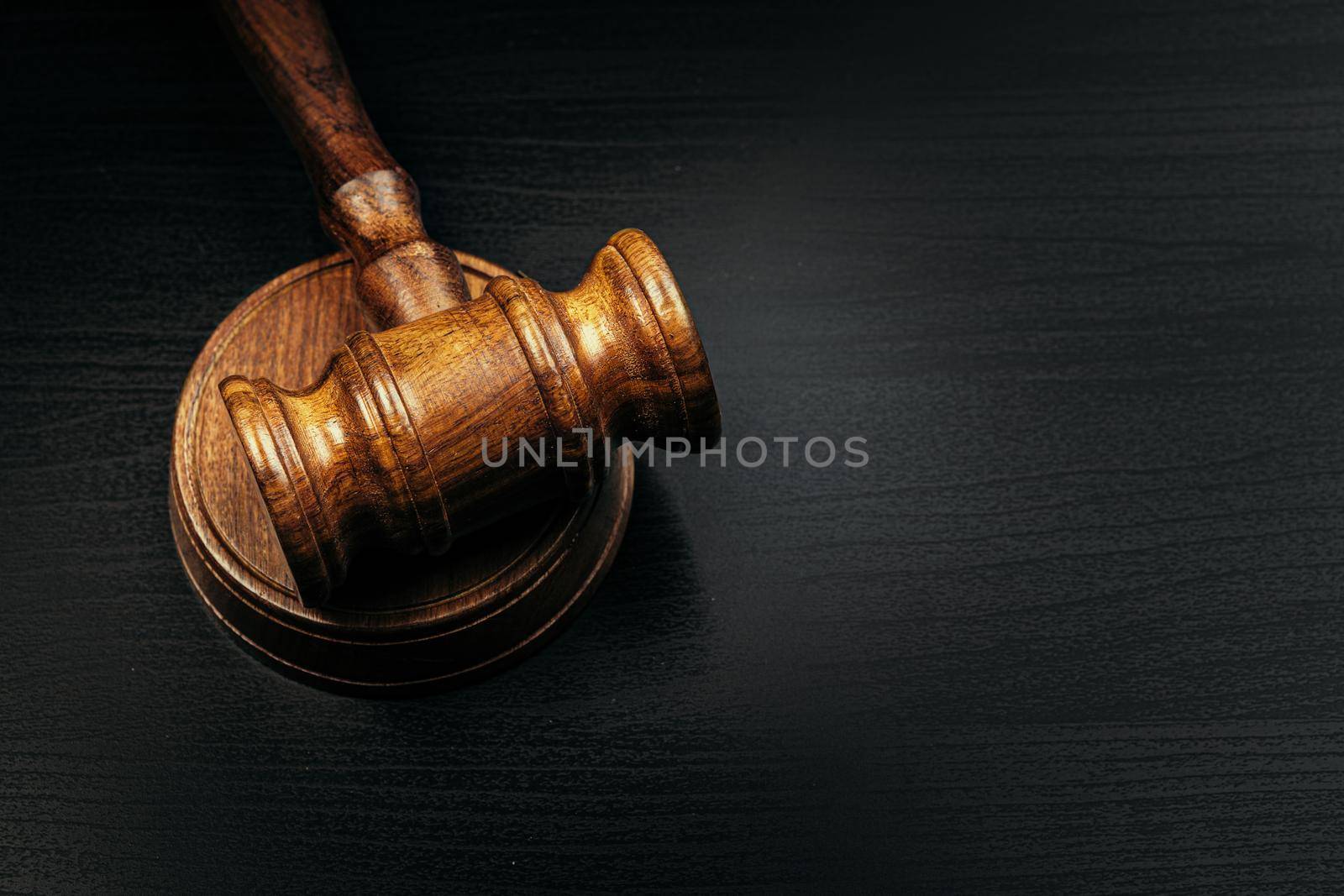 Judge's gavel on wooden table in dark. High quality photo