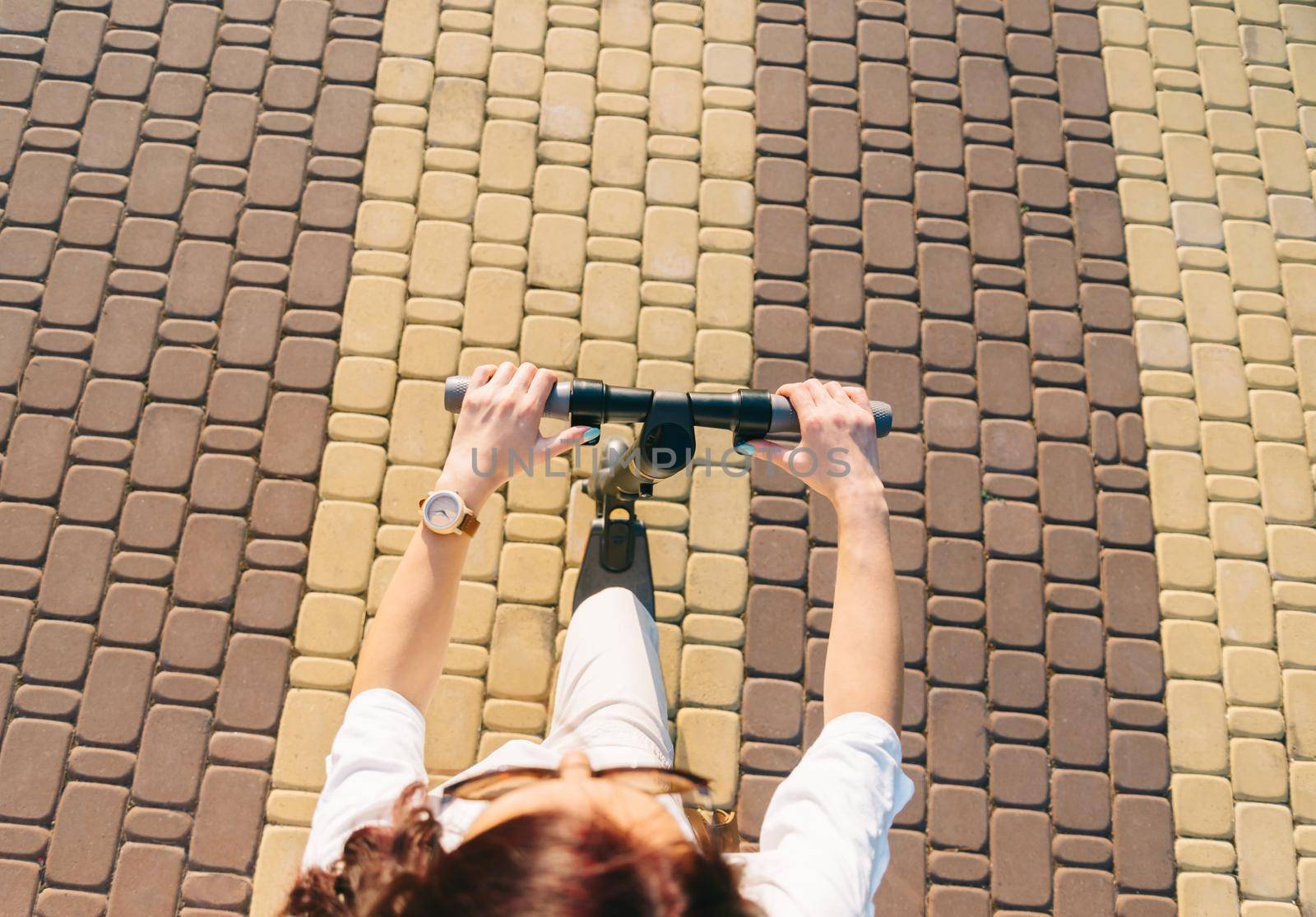 Top view of woman riding an electric scooter in street. by alexAleksei