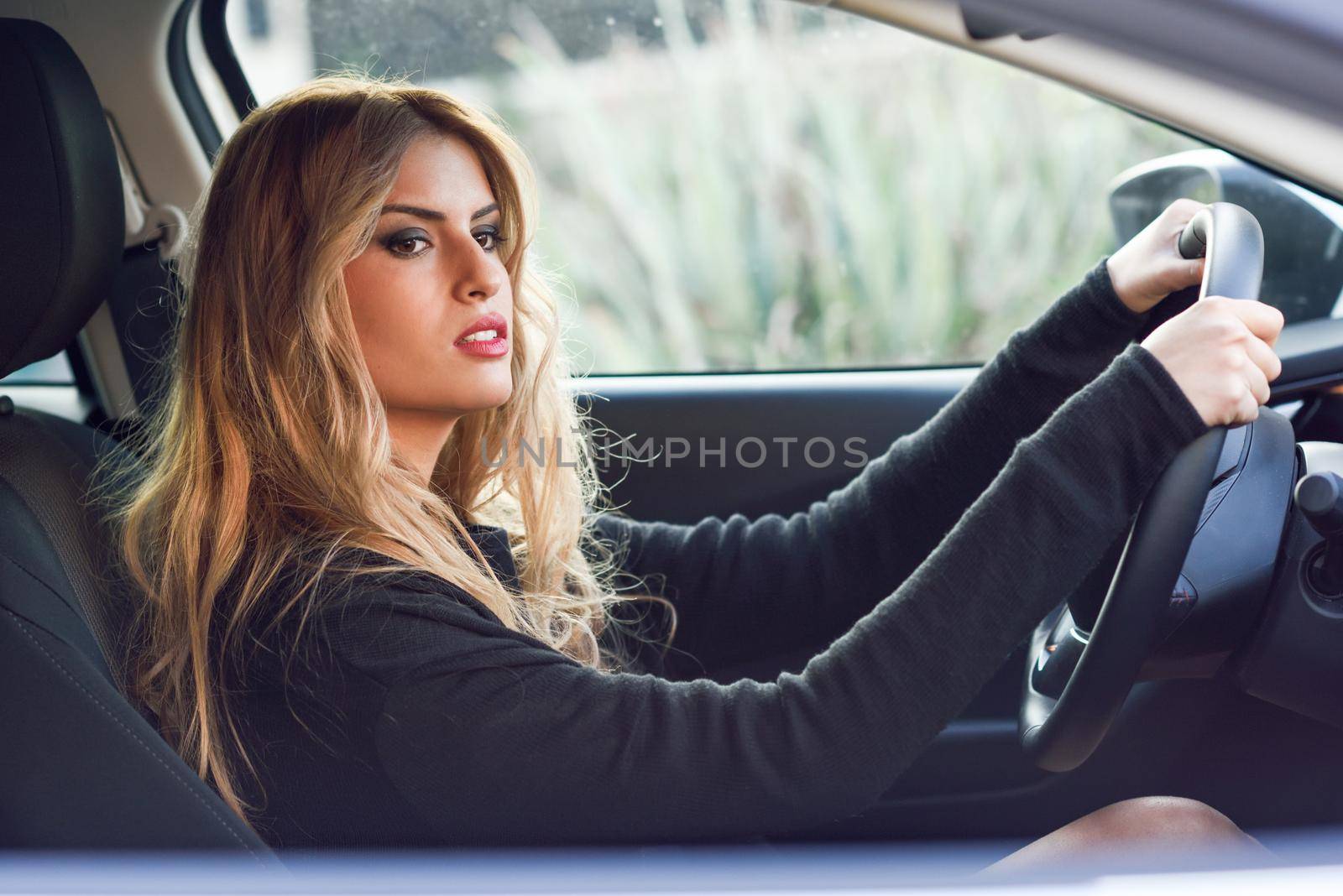 Blondie young woman driving a sport car by javiindy