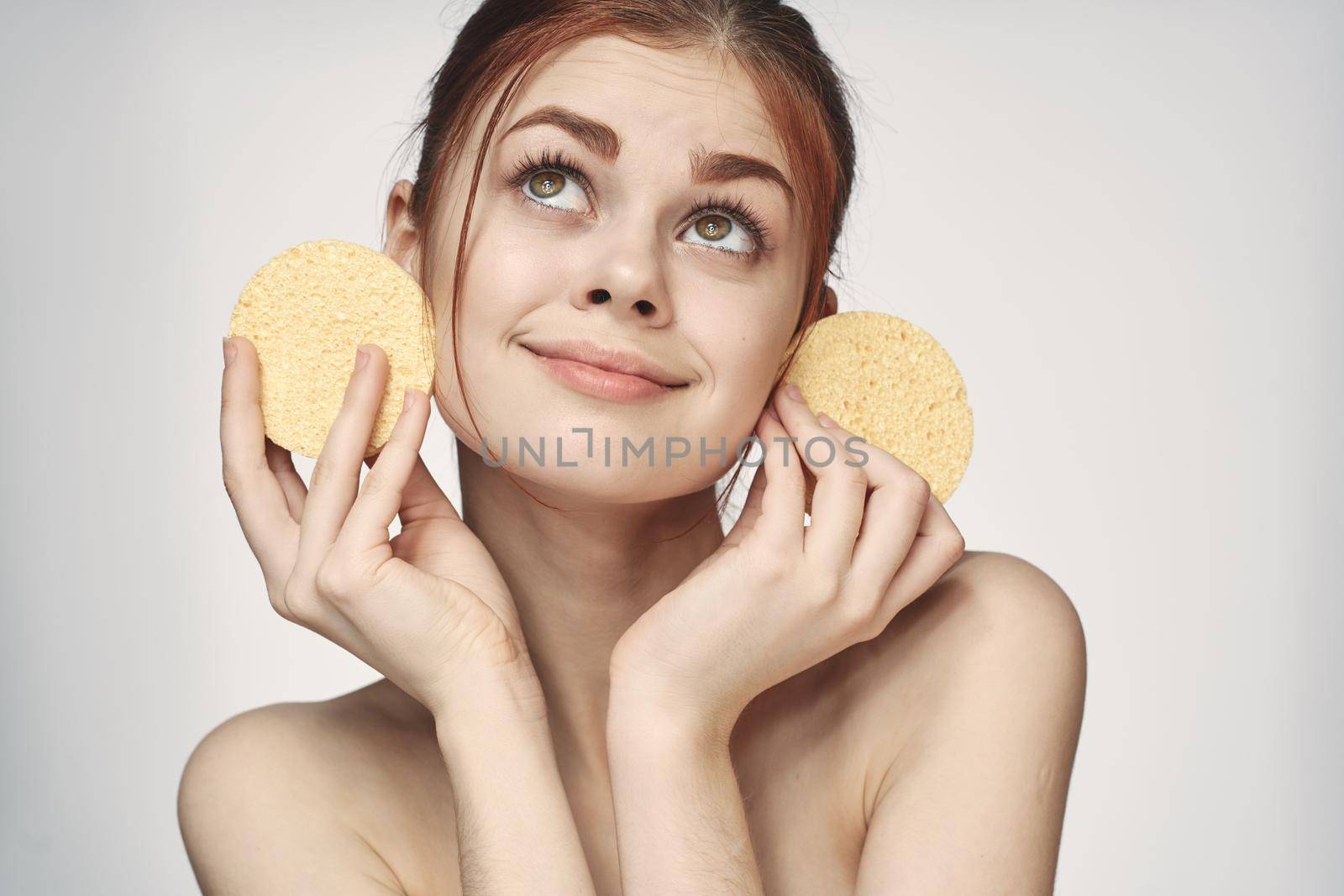 woman yellow sponge clean skin hygiene light background. High quality photo
