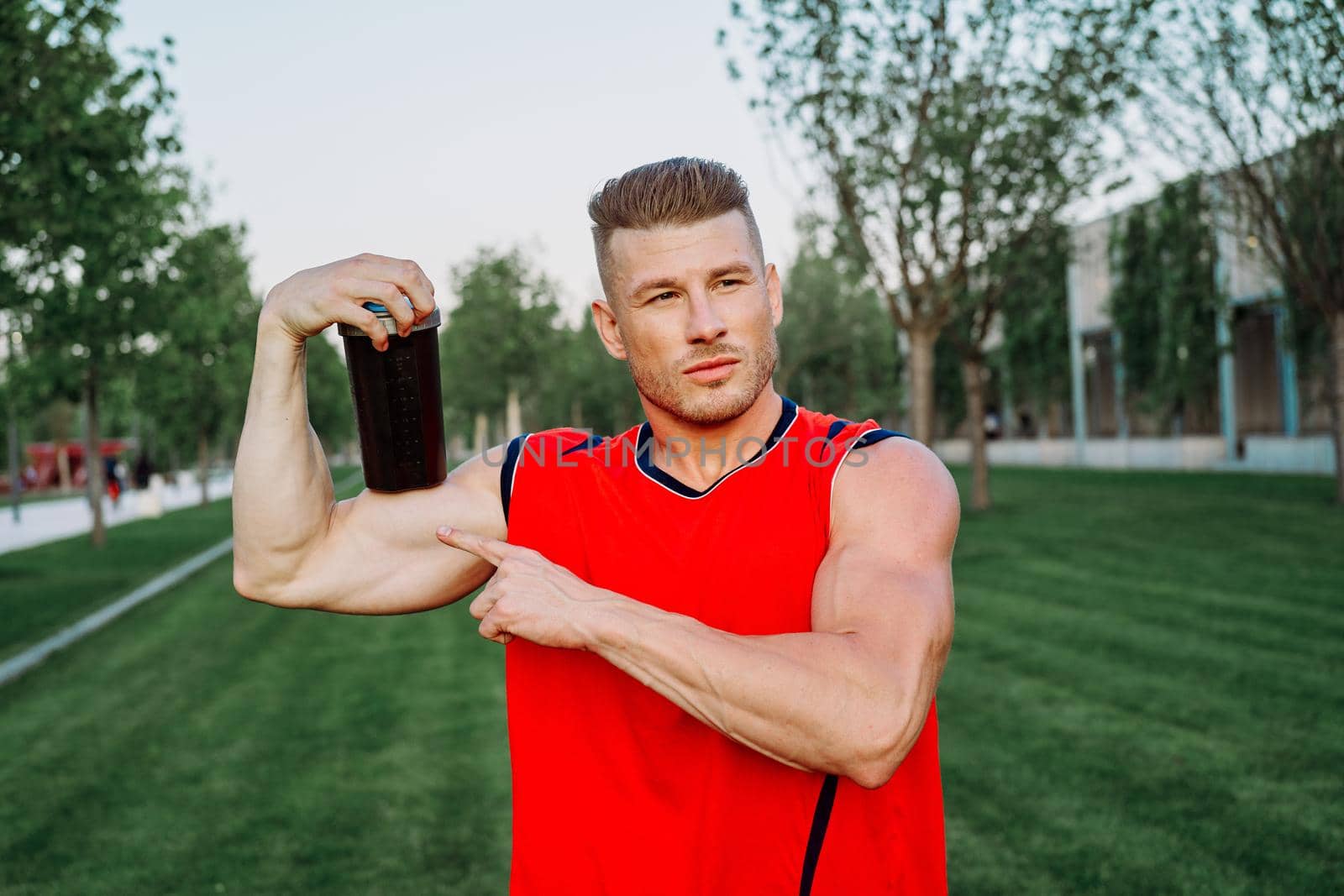 sporty man in the park outdoors glass with drink. High quality photo