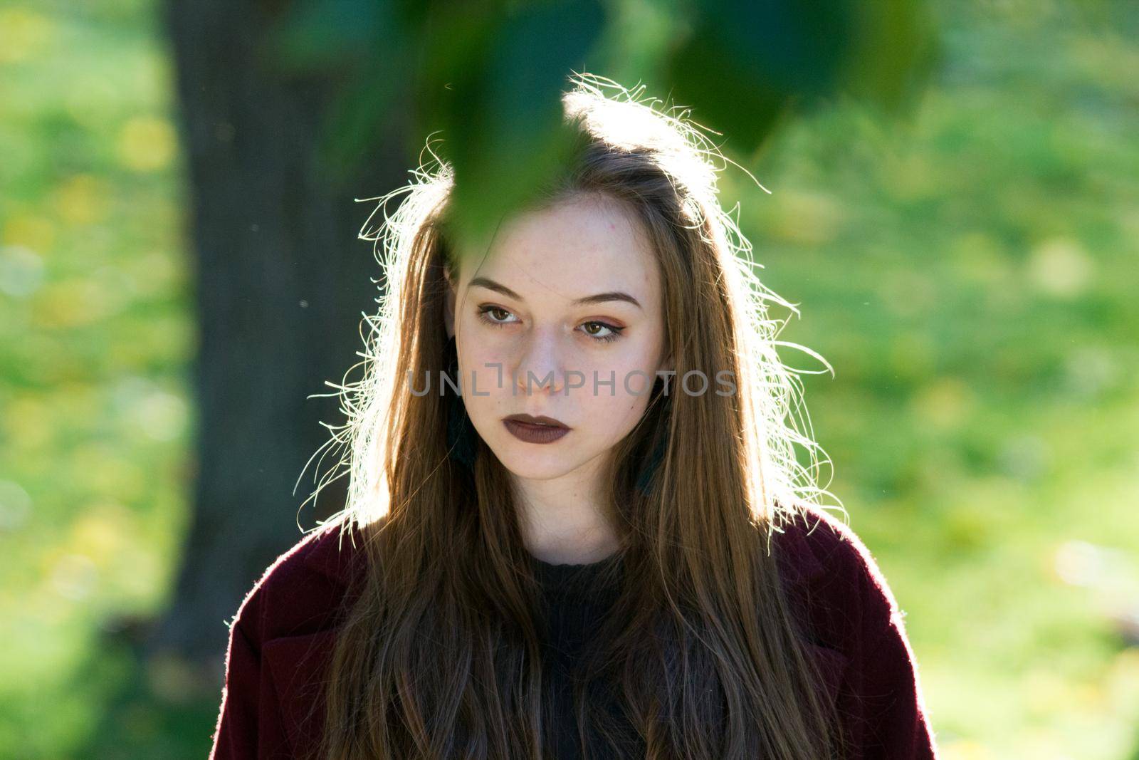 Beautiful girl inspiredly looking straight. Natural contour lighting. Portrait