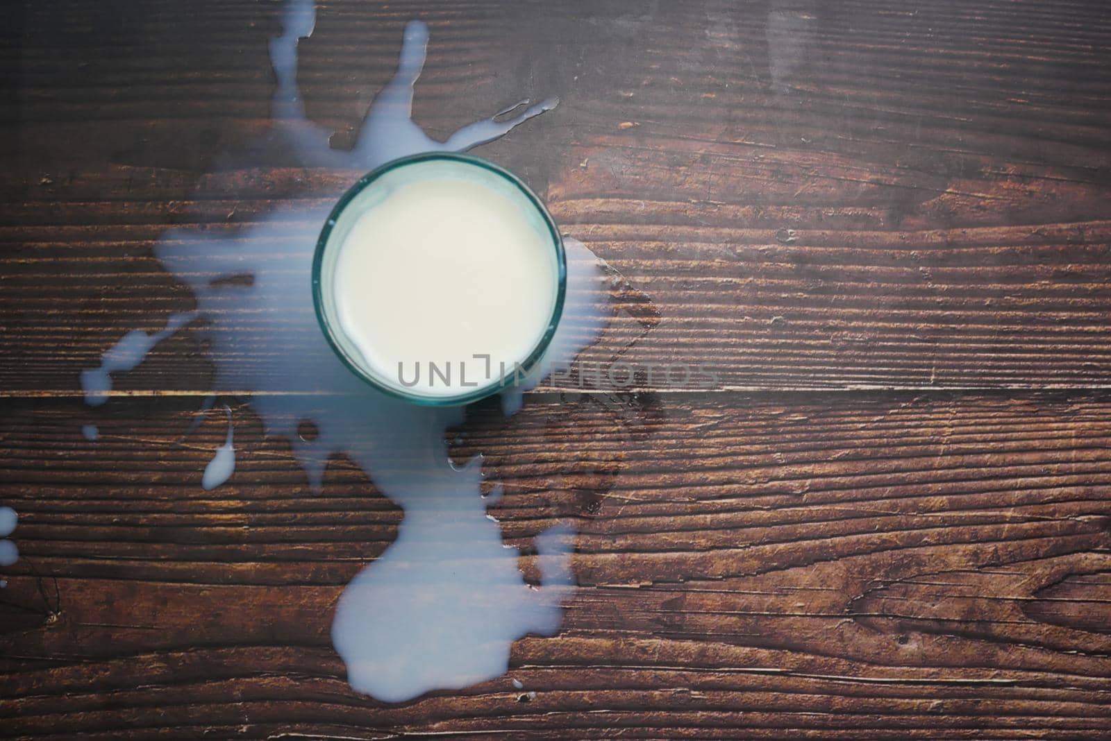 milk spilling on table, top view .