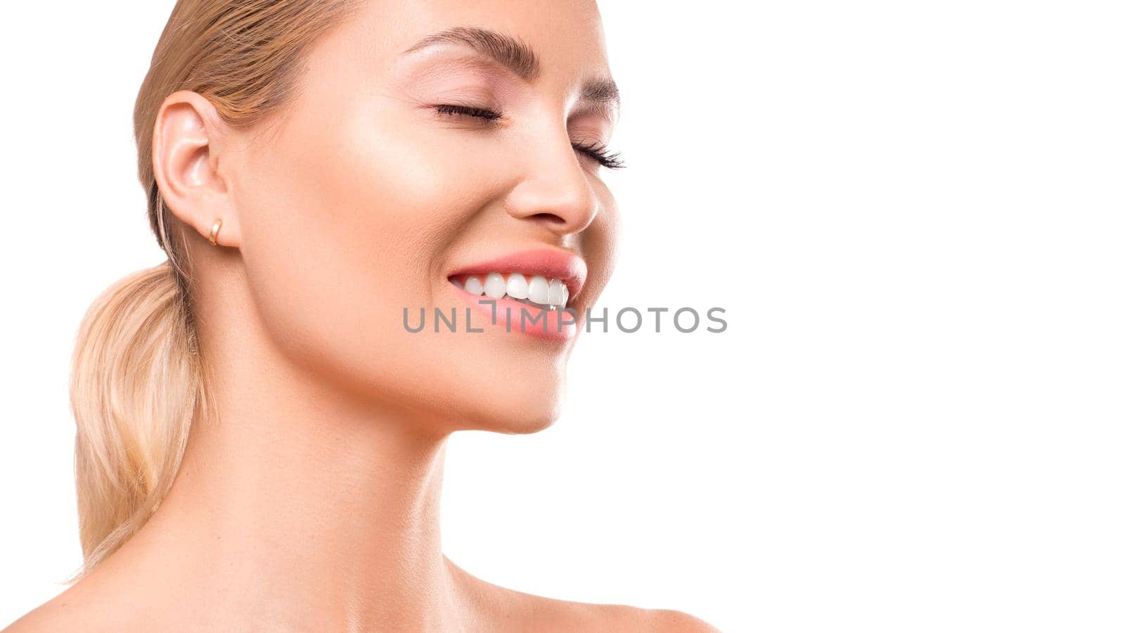 Portrait of a smiling young woman with closed eyes. Skin care concept.