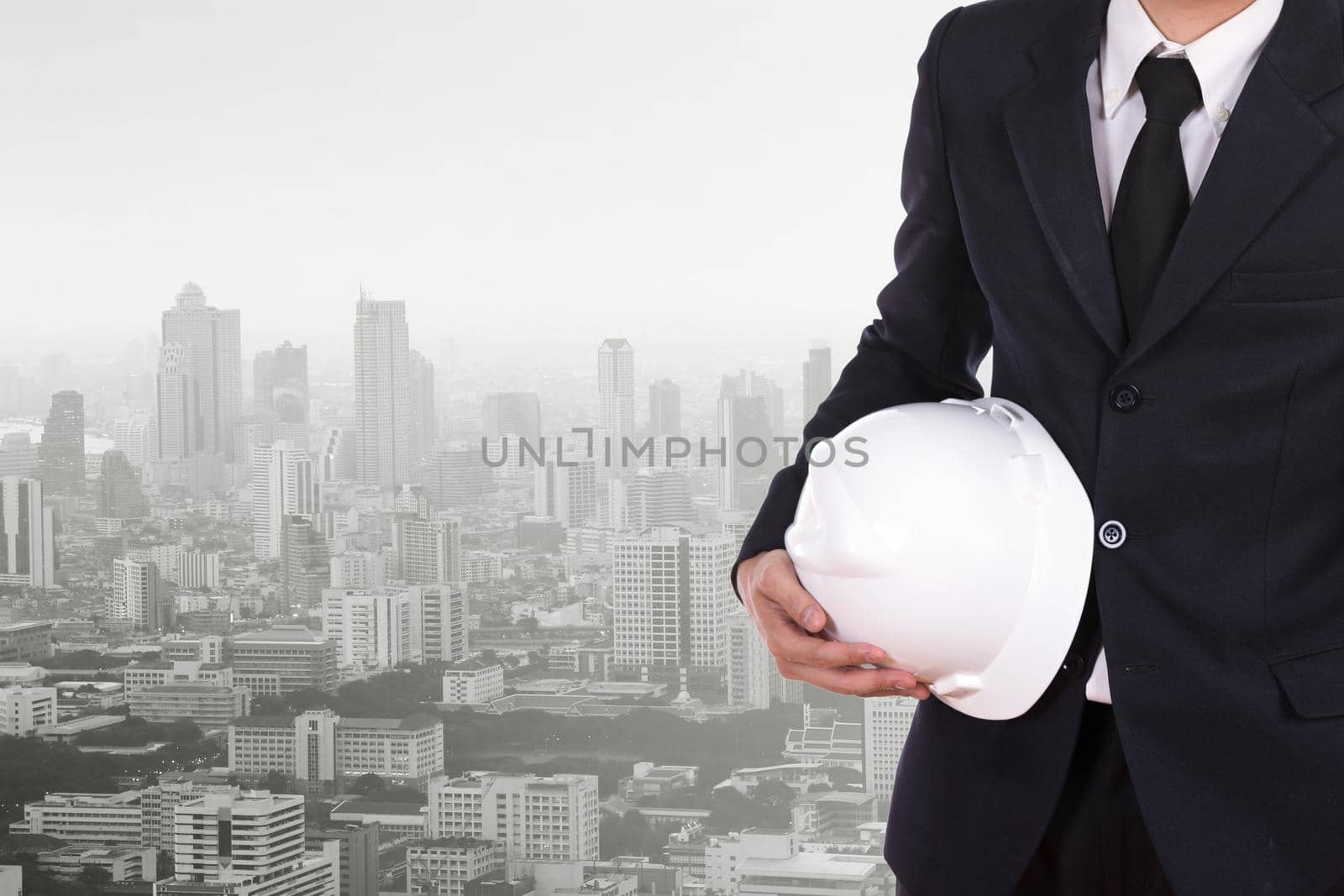 engineer holding white helmet with city background by geargodz