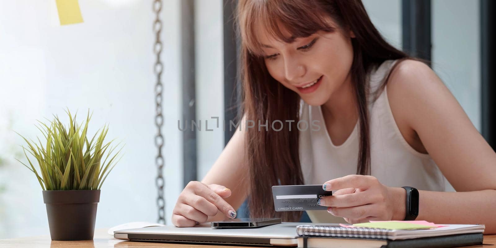 Smiling woman use mobile phone for shopping online with credit card.