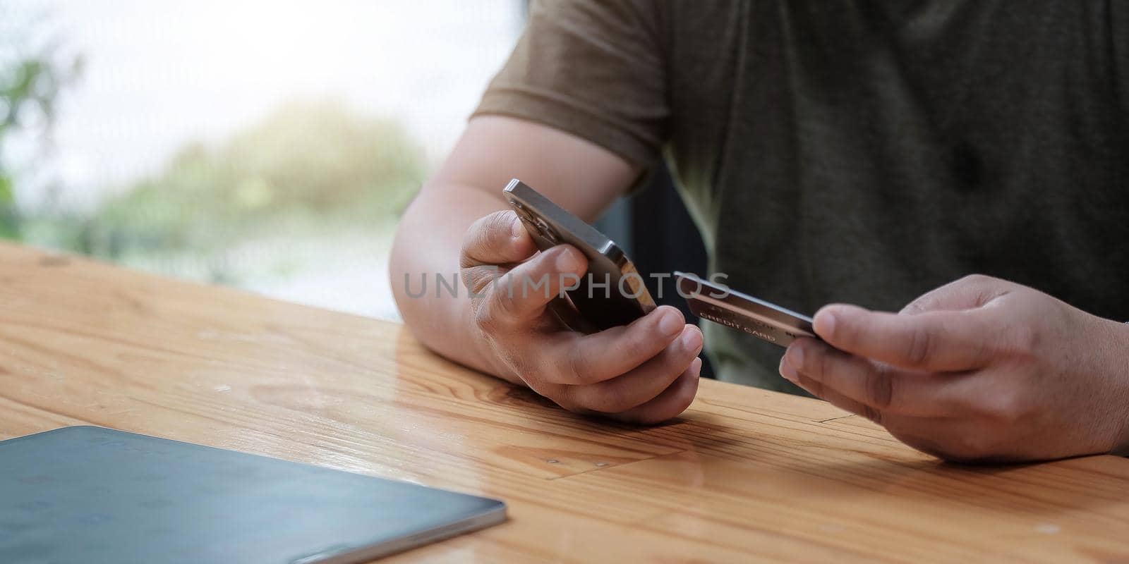 Man holding credit card and using smartphone at home, businessman shopping online, e-commerce, internet banking, spending money, working from home concept.