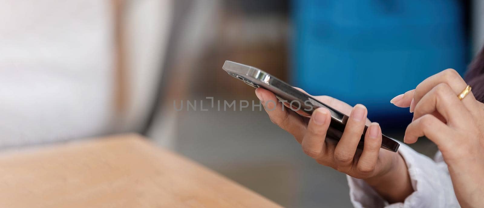 Close up of woman using cellphone and typing text message on smartphone device by wichayada