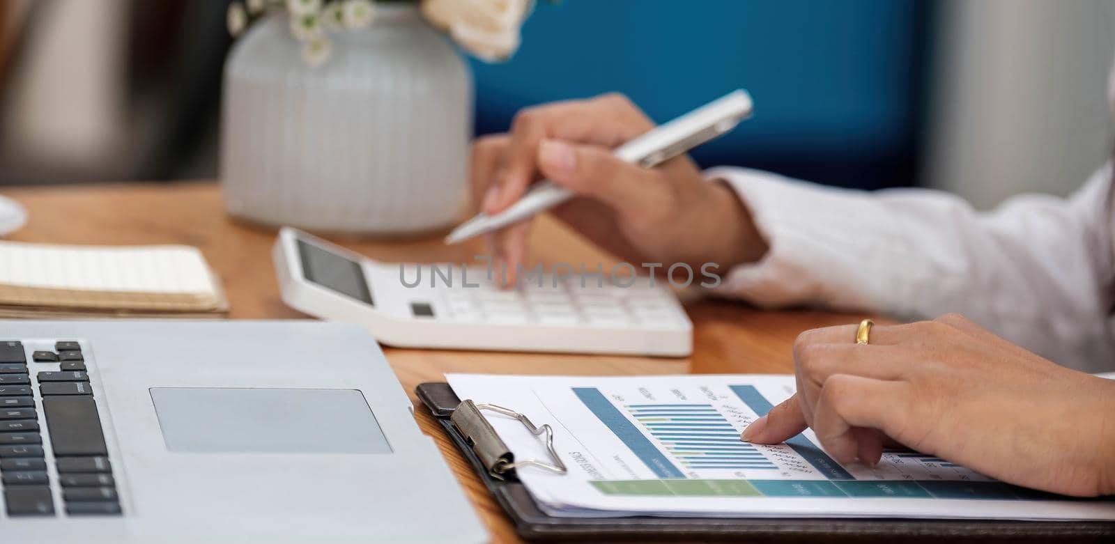 Accountant using a calculator to calculate the numbers. Accounting , Accountancy from financial report and calling to consultant, Calculation Concept. by wichayada