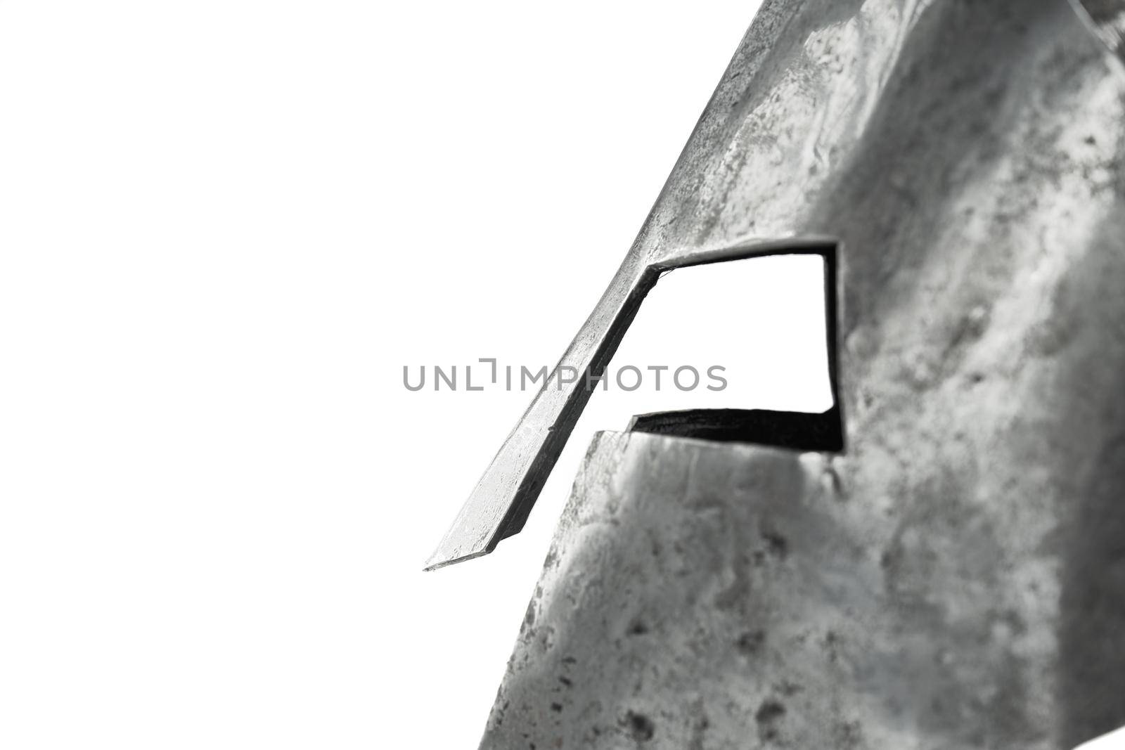 Closeup of ancient iron spartan helmet isolated on white studio background. Side view of medieval armor, archeological souvenir from past, metal tough head protection.