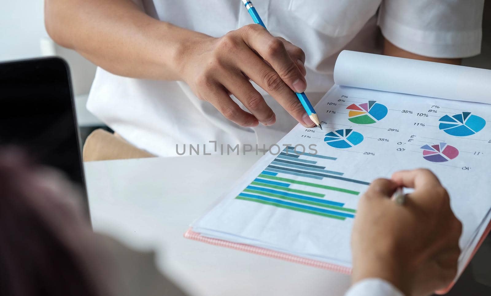 Business team analyzing income charts and graphs with modern laptop computer. Top view close up business analysis and strategy concept..