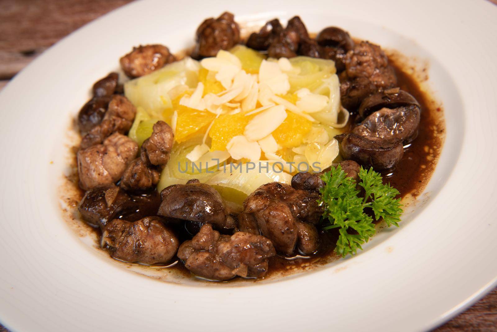 Recipe of sweetbread and lamb kidney with cocoa, leek whistles with almonds and oranges. High quality photo