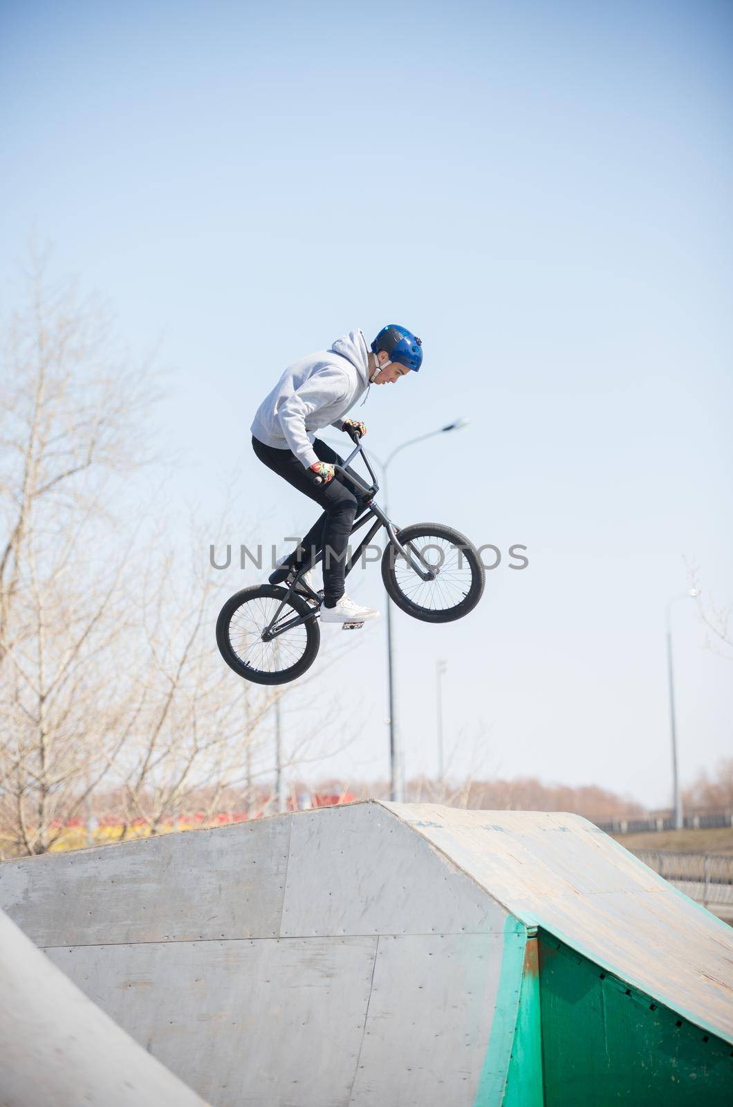 A bmx rider in the skatepark in the air. Daylight. Mid shot