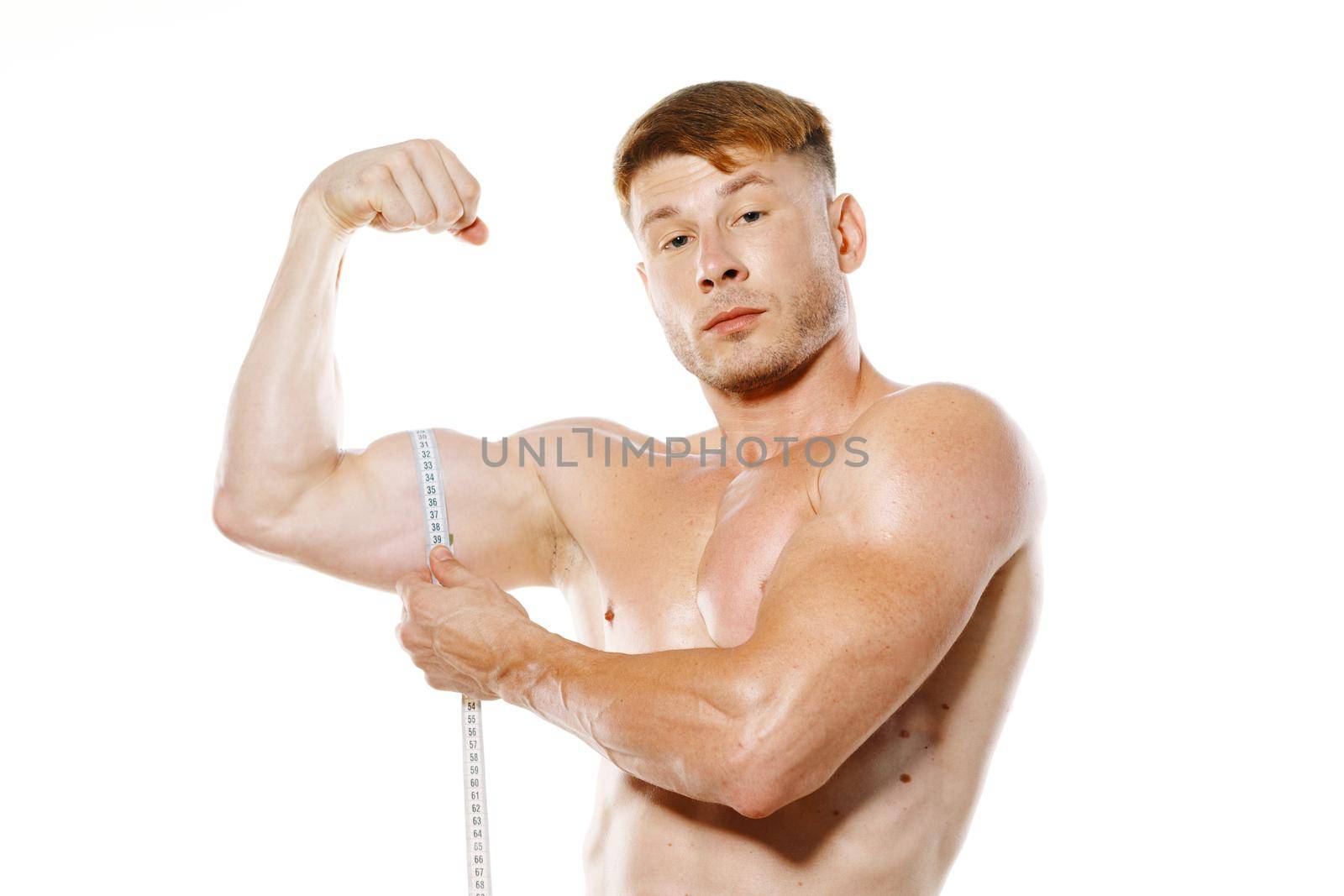 athletic man measures muscles fitness posing bodybuilder. High quality photo
