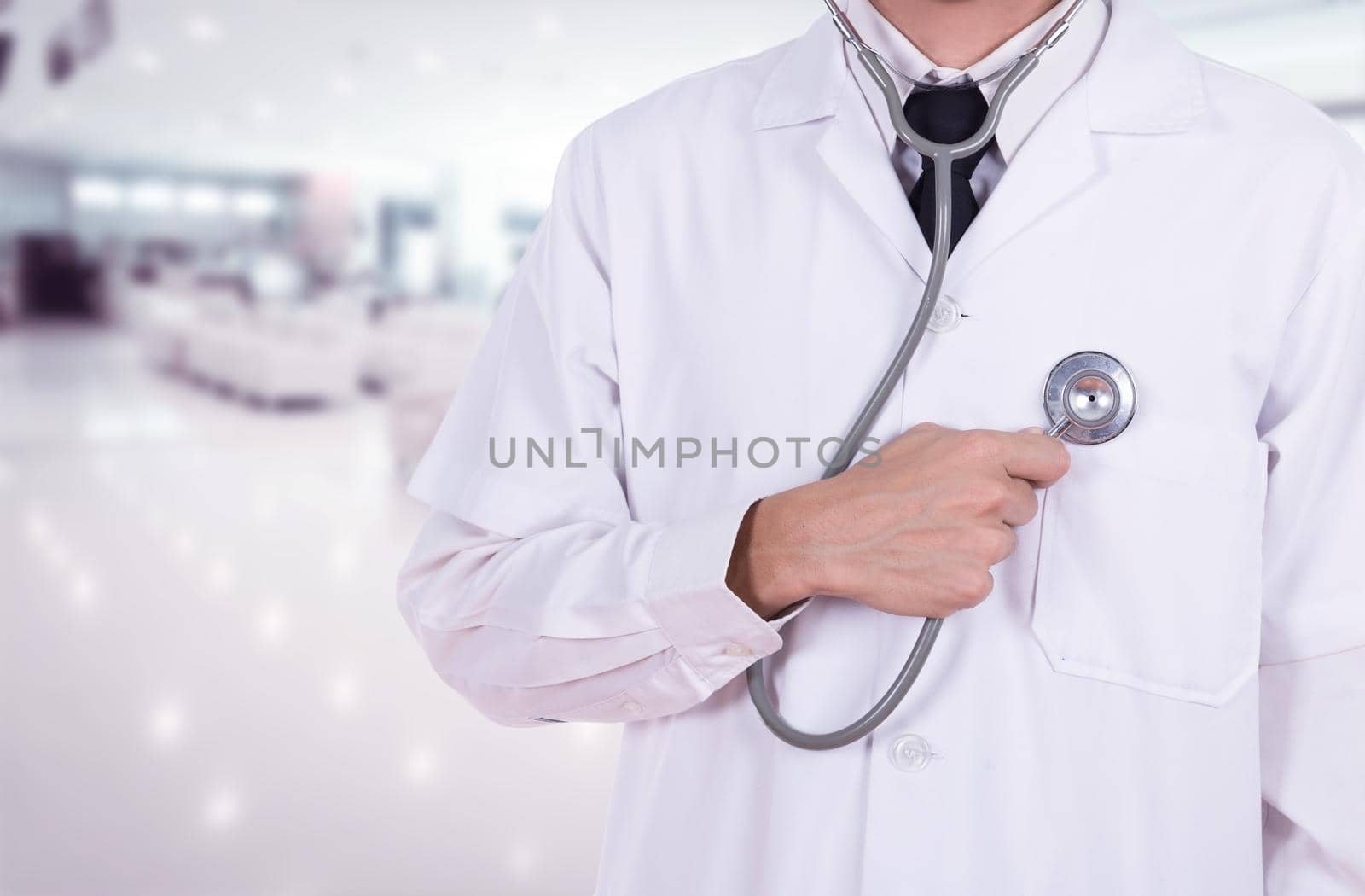 doctor listening his heart with stethoscope in hospital background
