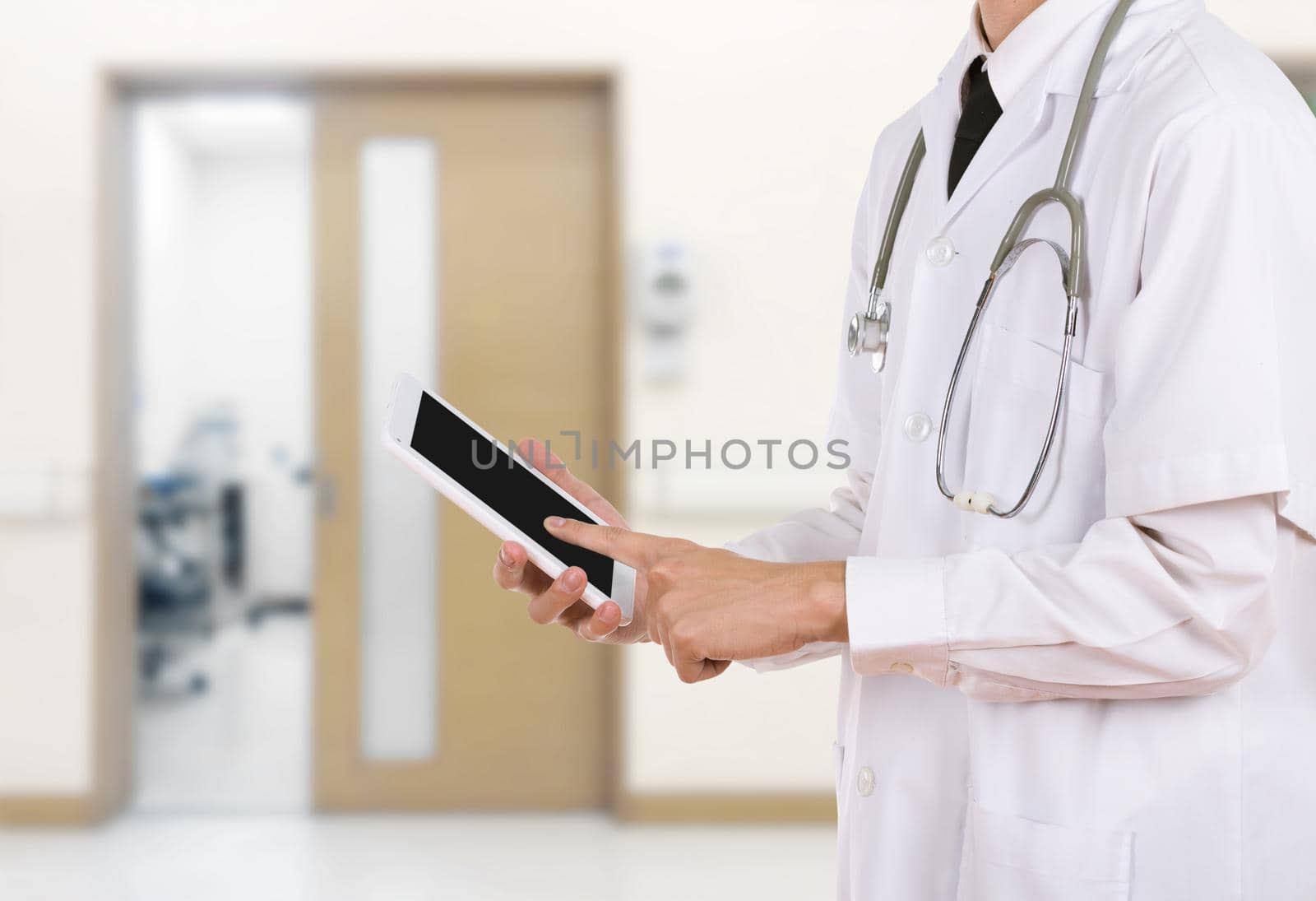 Doctor working on a digital tablet in hospital background
