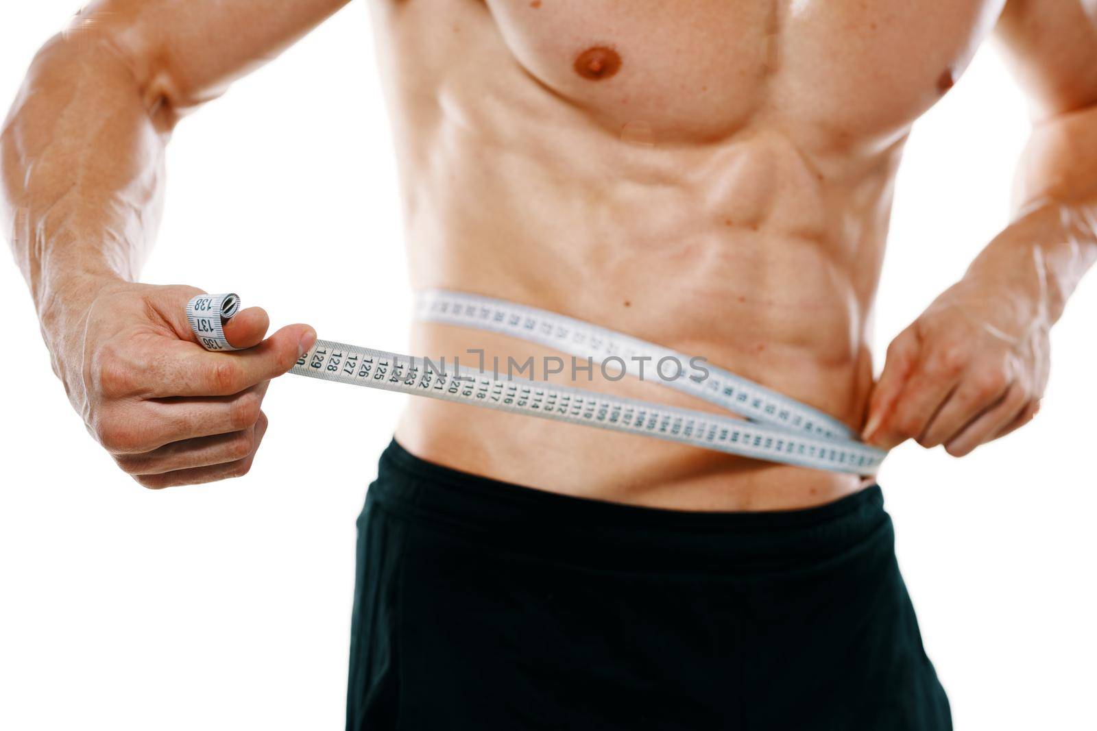 athletic man with pumped up muscular body measures with tape. High quality photo