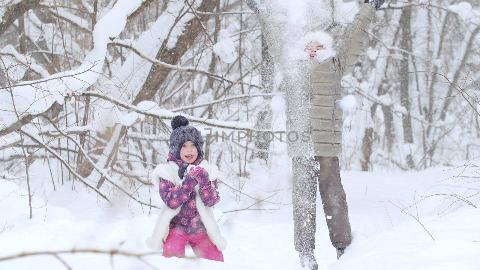 Two little girls playing with snow in winter forest. by Studia72