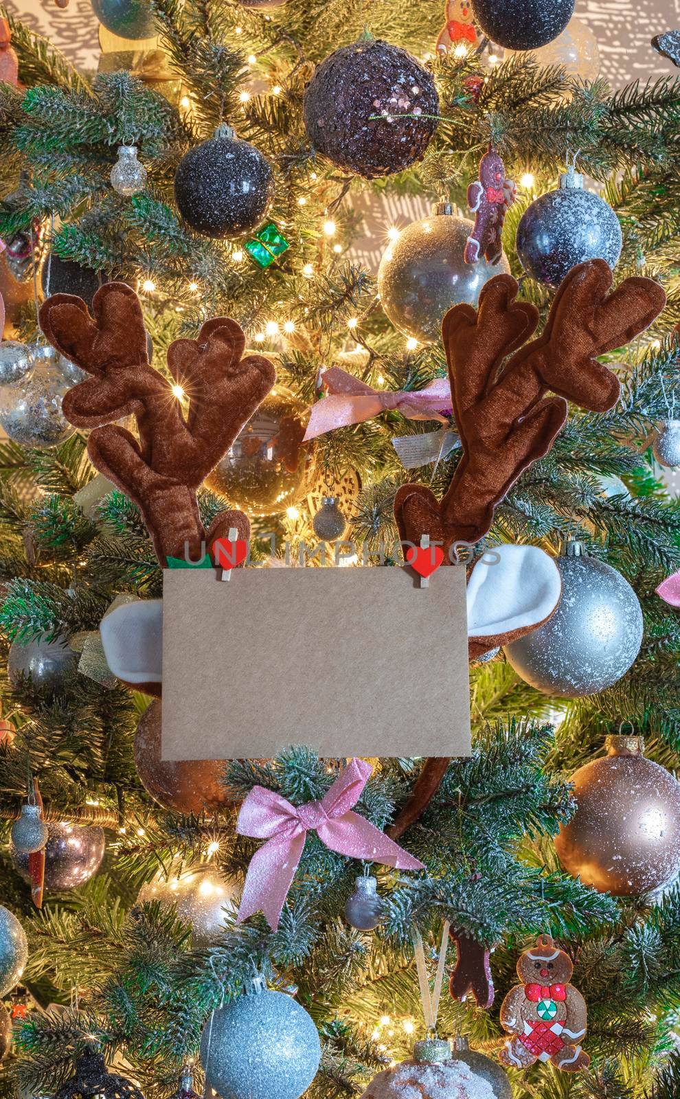 Christmas mail envelope with blank letter in decorated tree with reindeer ears for copy space close to, background, Holiday concept by Annebel146