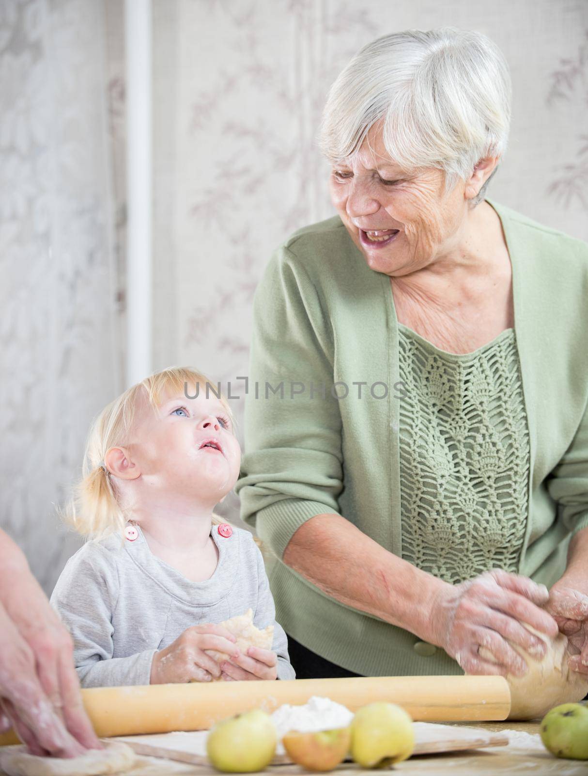 A grandmother making little pies with a little girl. Mid shot