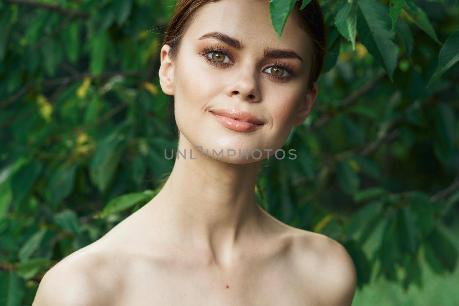 smiling woman skin care bare shoulders green leaves nature Lifestyle. High quality photo