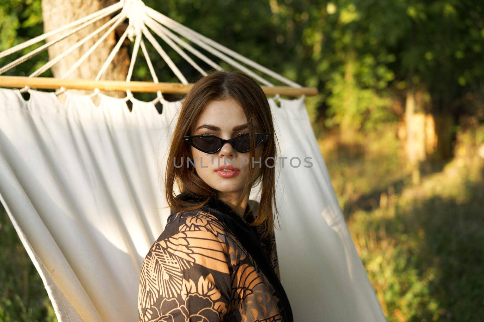 woman in sunglasses lies in a hammock outdoors summer lifestyle. High quality photo