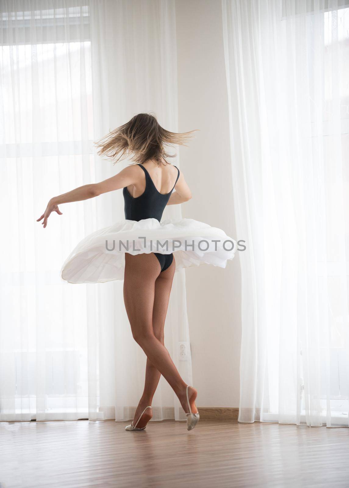 Ballerina makes a turn, in the dance studio by Studia72