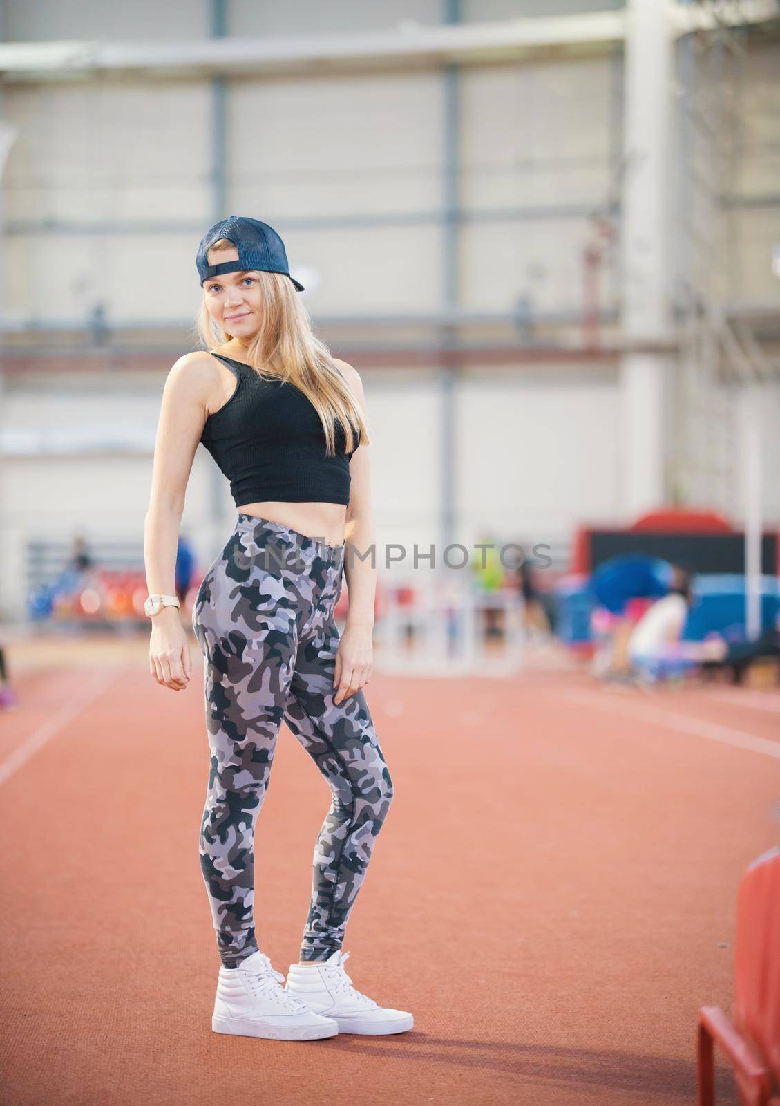 Young athletic woman in military legging posing. Full height