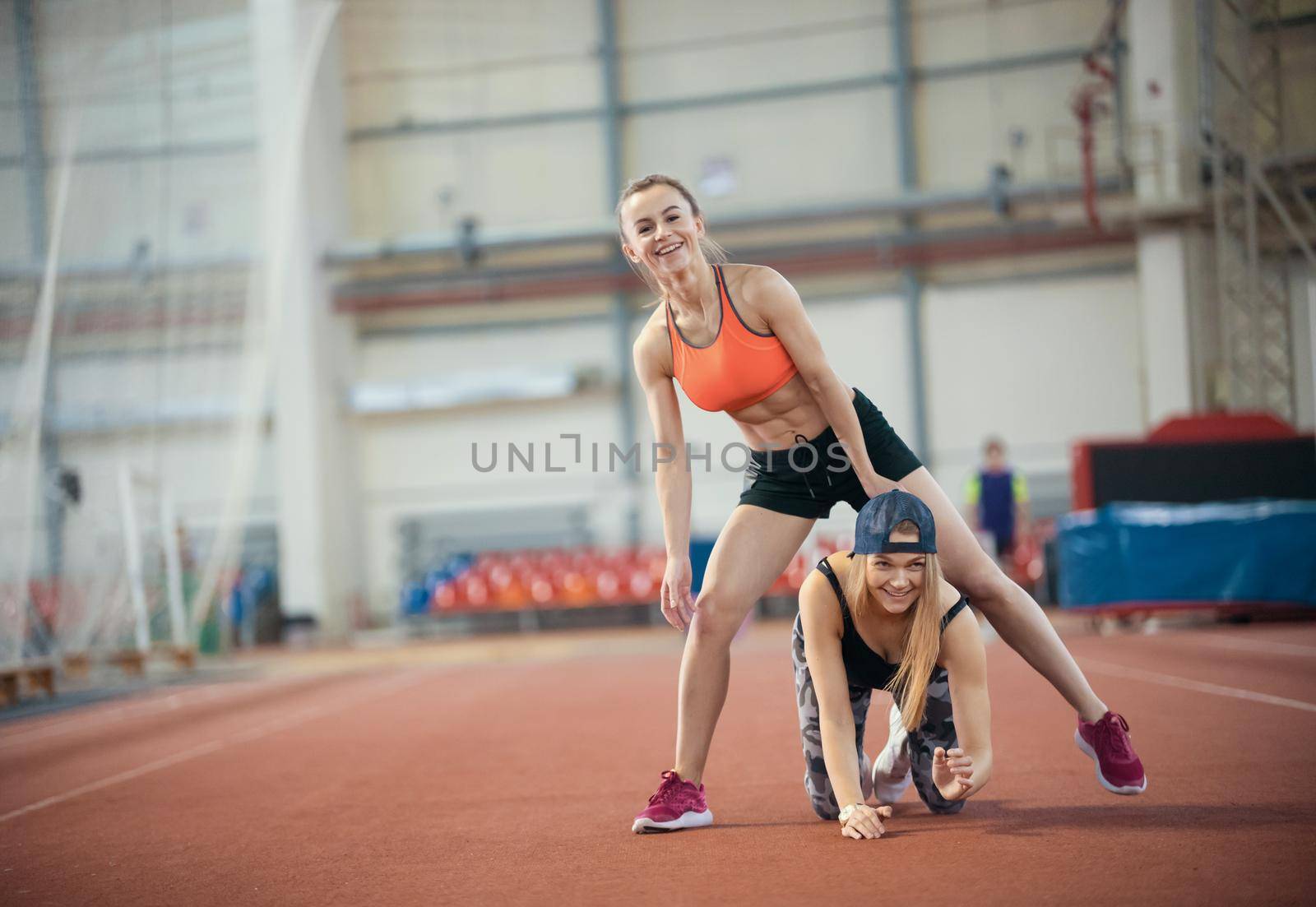 Two young women doing exercises and warming up together. Mid shot