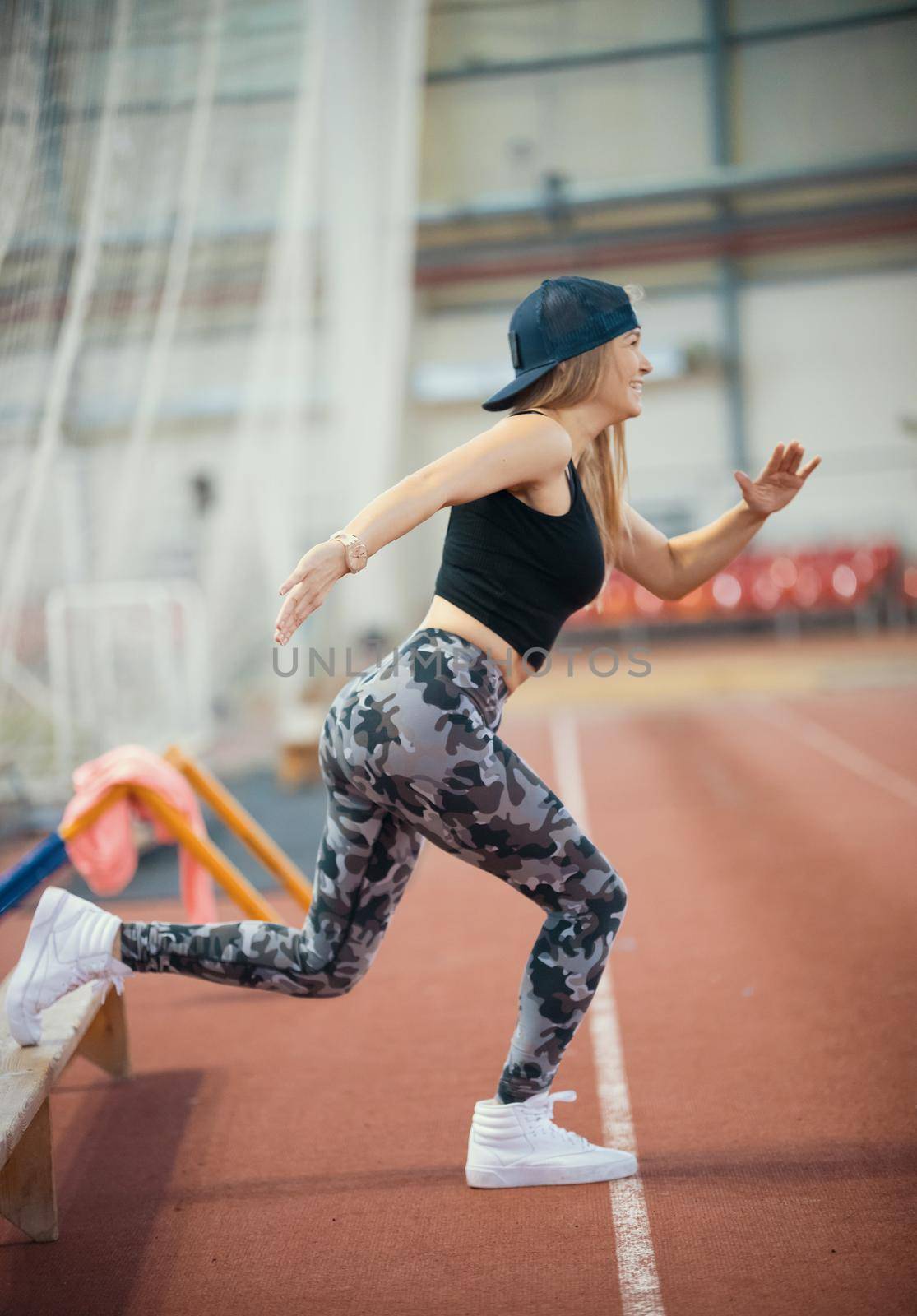 Young athletic woman in leggings working out using a bench. Mid shot