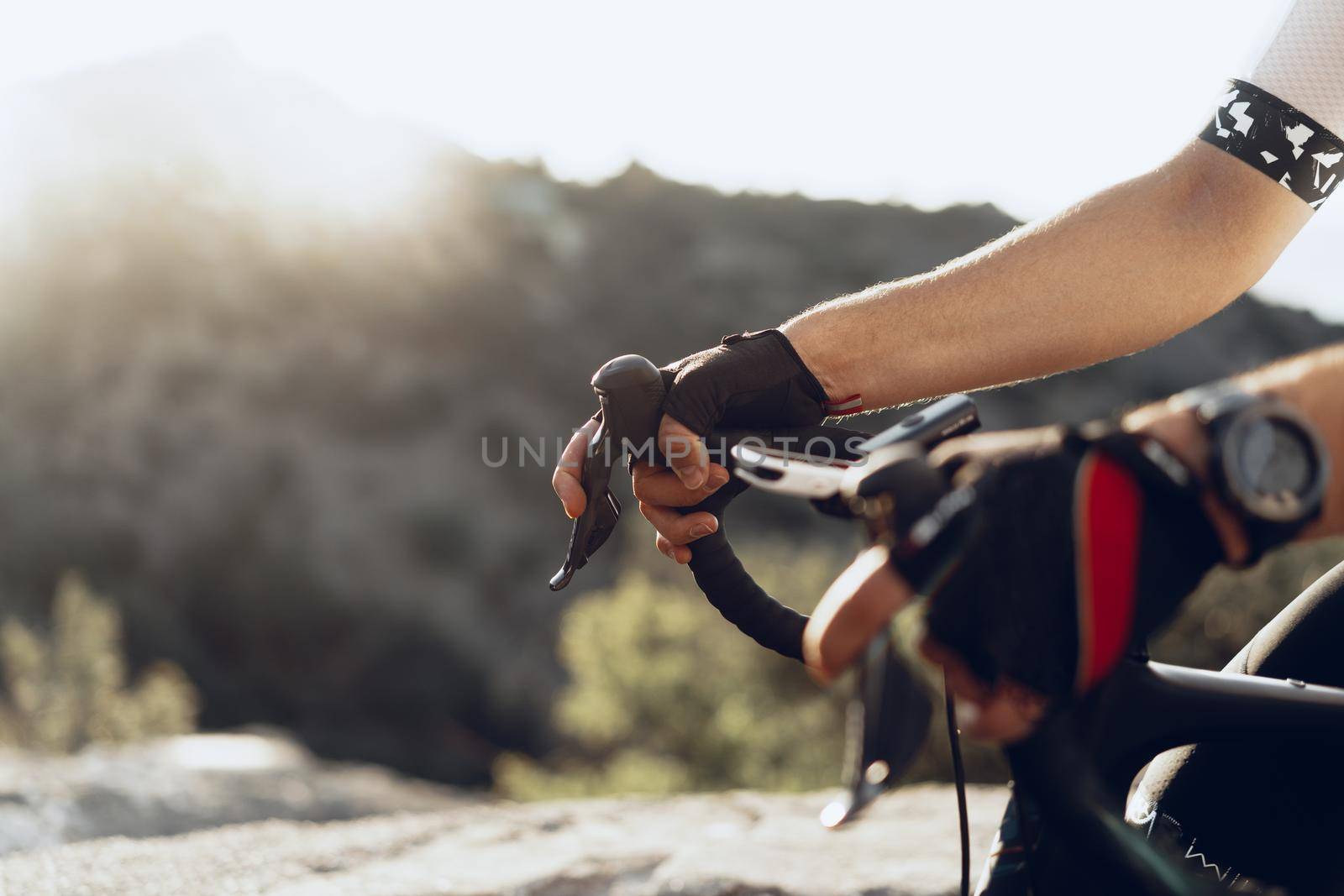 Hands of a professional cyclist in gloves on handle bar of a bicycle close up