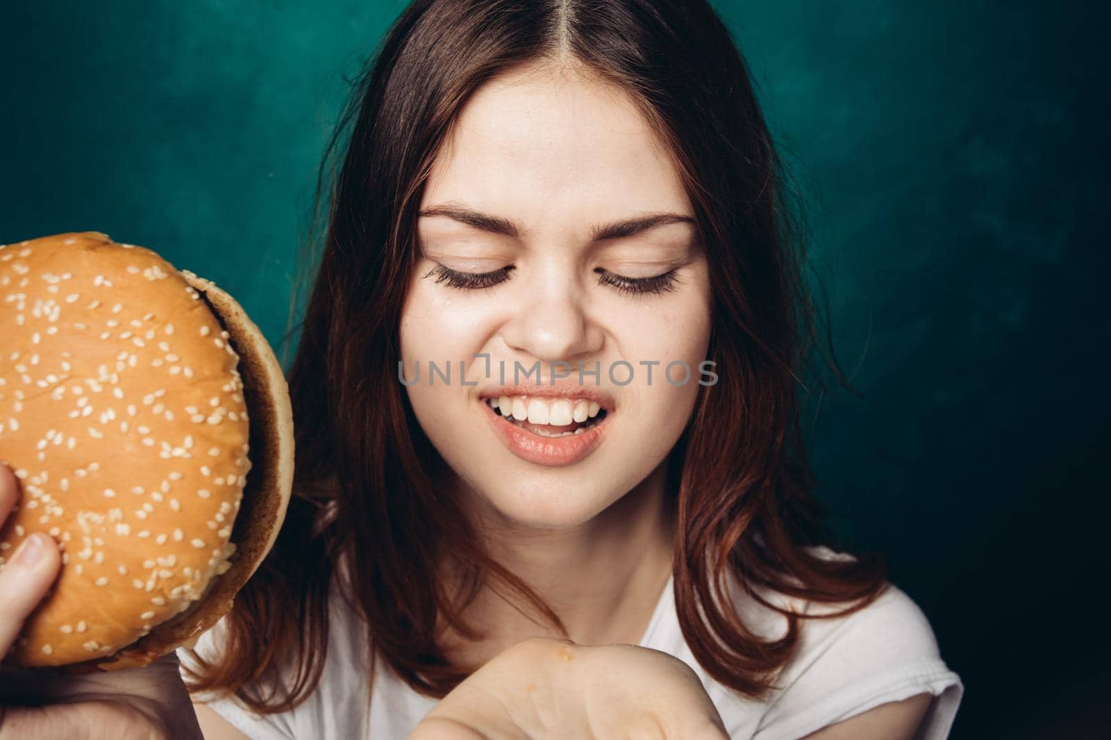 woman eating hamburger fast food snack close-up by Vichizh